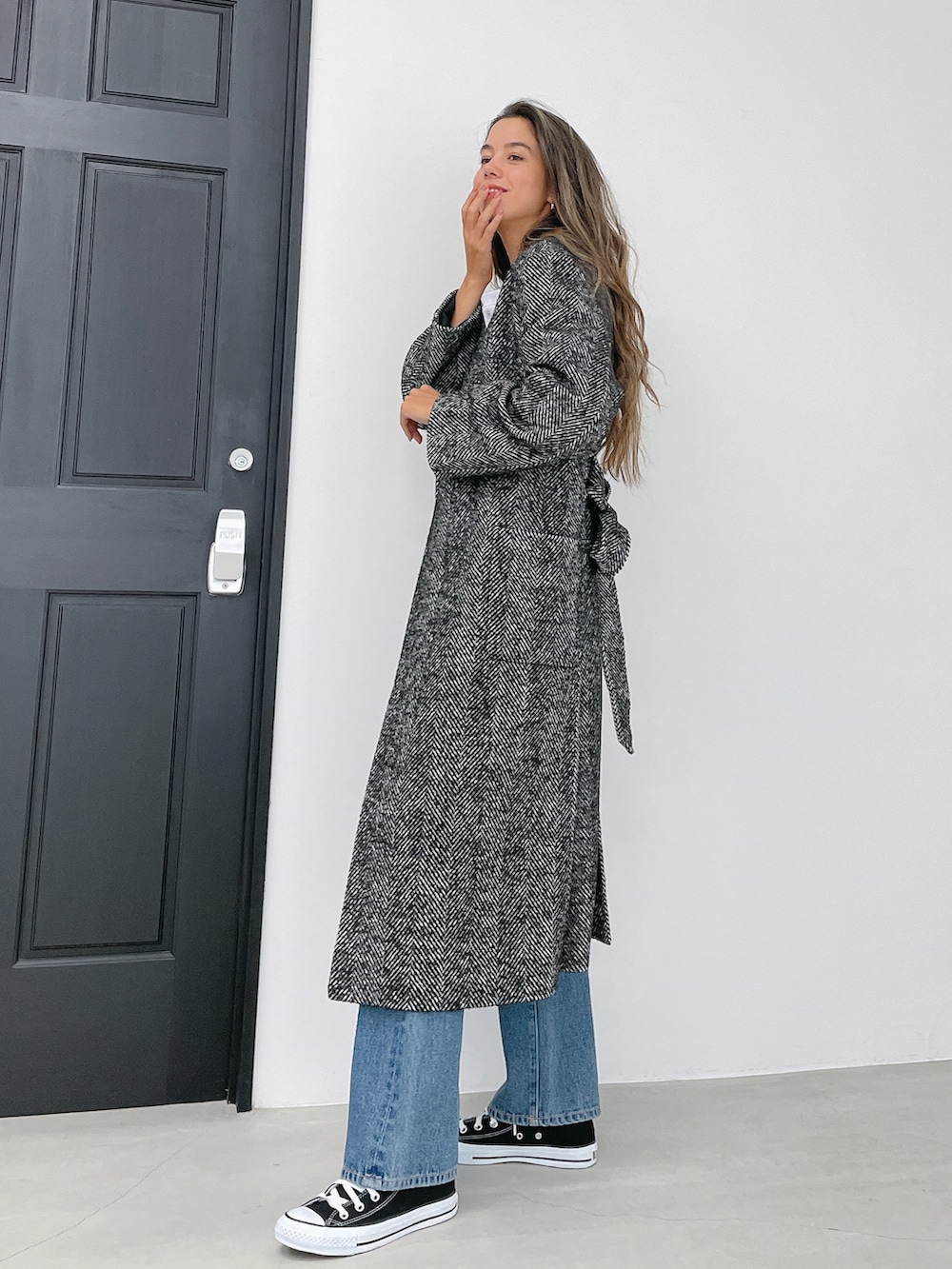 ホワイト系のスウェットパンツ、ブラック系のその他アウター、ブルー系のデニムパンツを着用したレディースの冬コーディネートの2枚目の写真