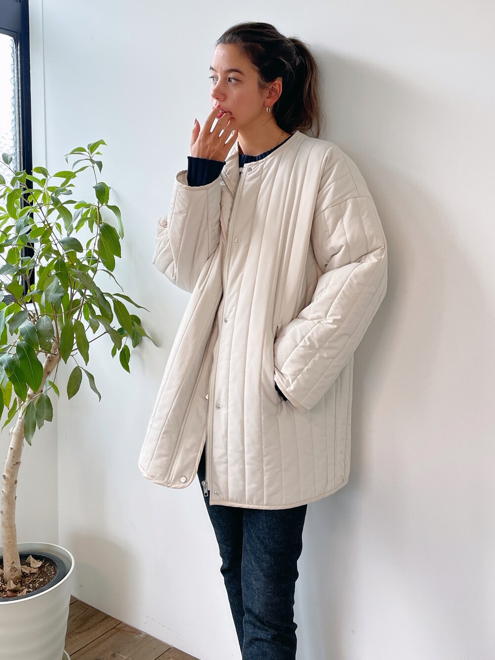 ブルー系のニット/セーター、ホワイト系のその他アウター、ブラック系のスニーカーを着用したレディースの冬コーディネートの2枚目の写真