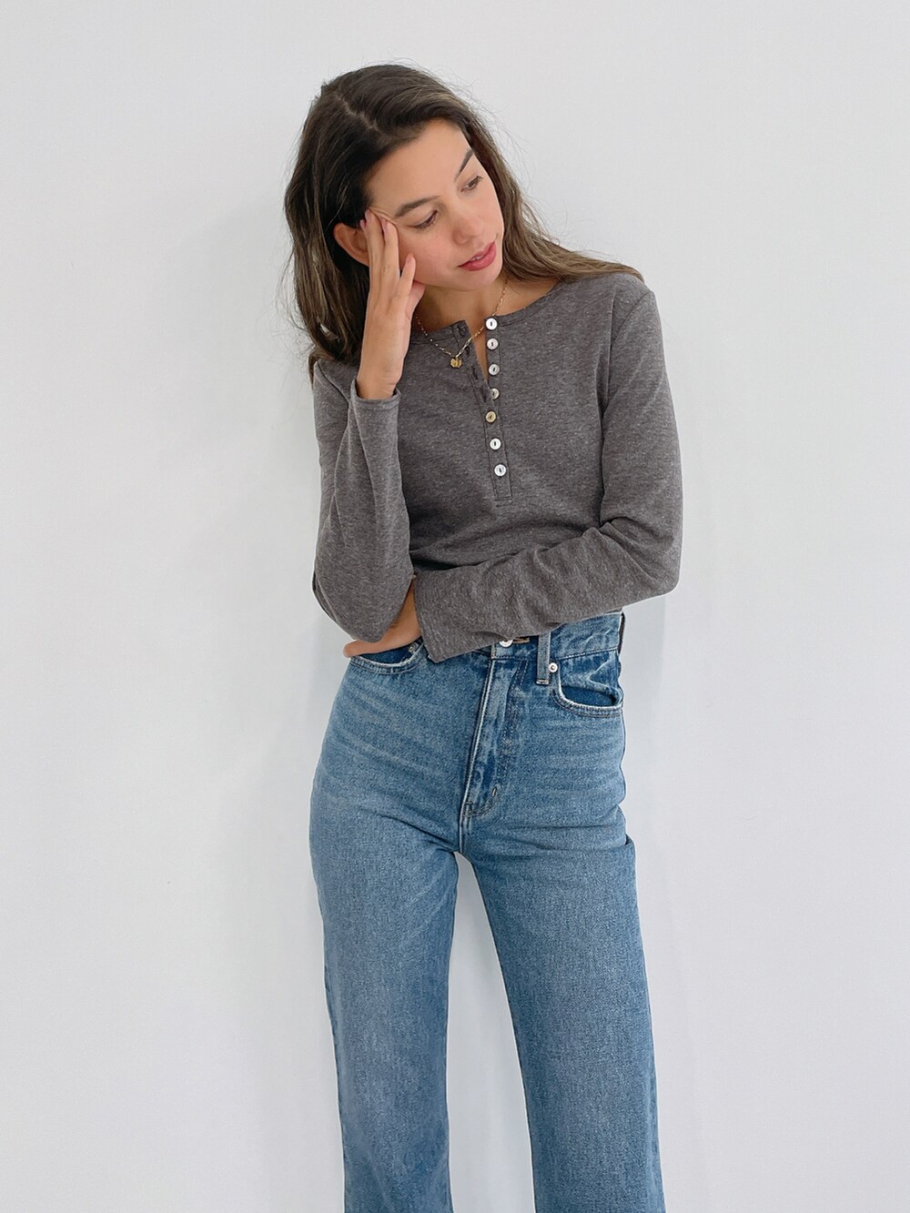 グレー系のTシャツ/カットソー、ブルー系のデニムパンツを着用したレディースの冬コーディネートの2枚目の写真