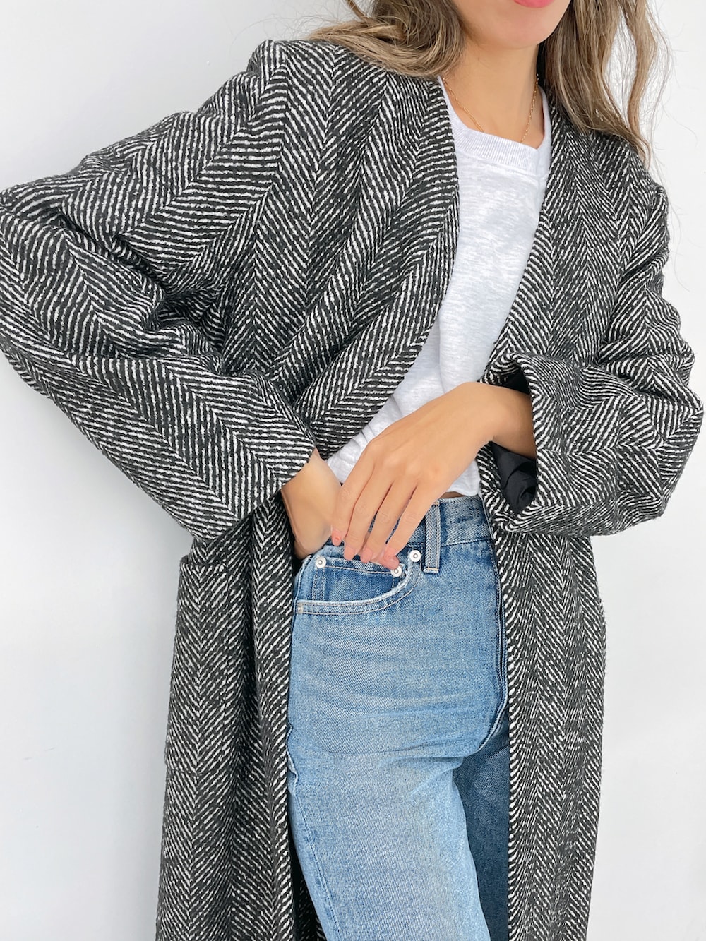 ホワイト系のスウェットパンツ、ブラック系のその他アウター、ブルー系のデニムパンツを着用したレディースの冬コーディネートの3枚目の写真