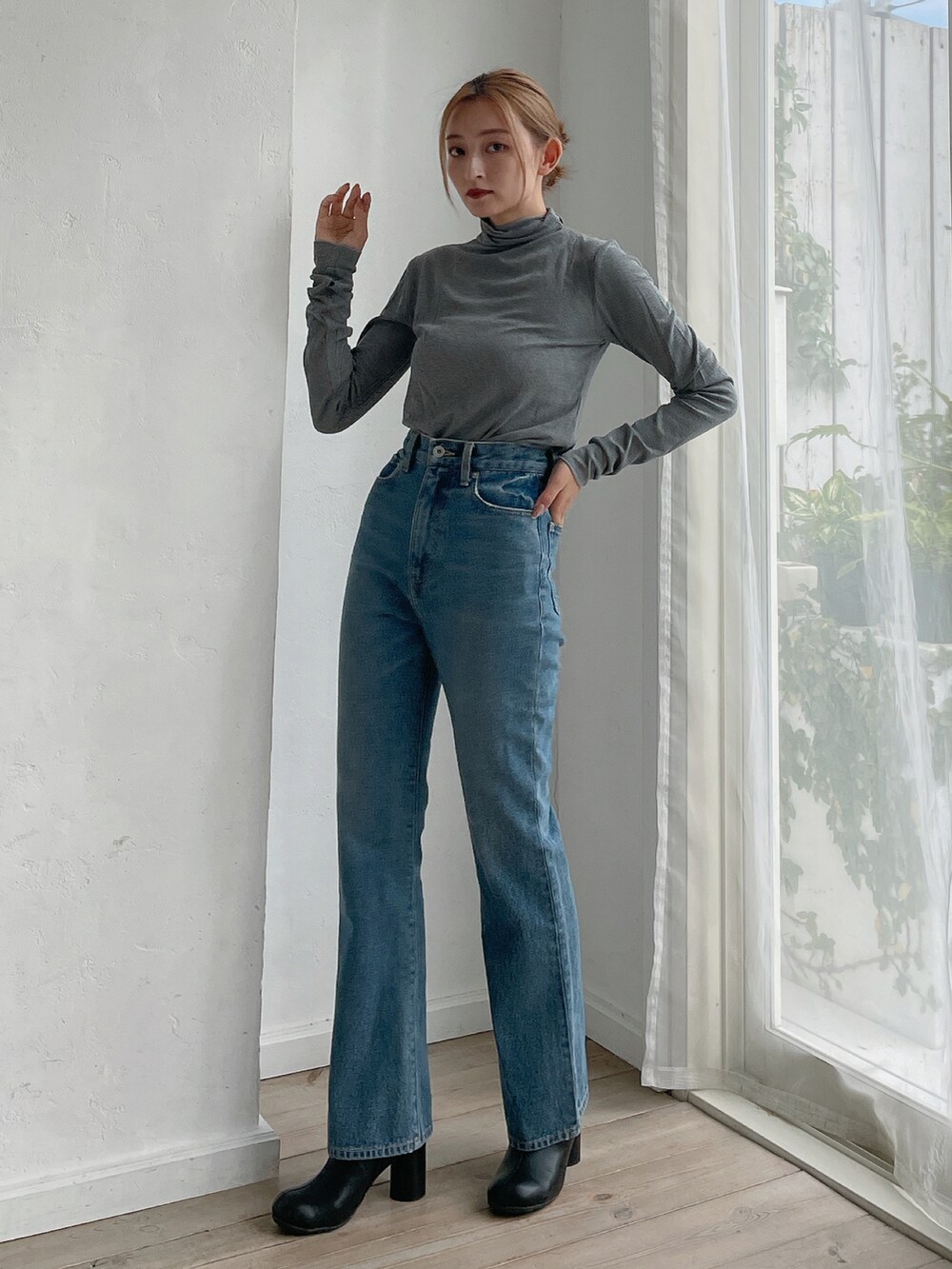 グレー系のTシャツ/カットソー、ブルー系のデニムパンツ、ブラック系のブーツを着用したレディースの秋コーディネートの3枚目の写真