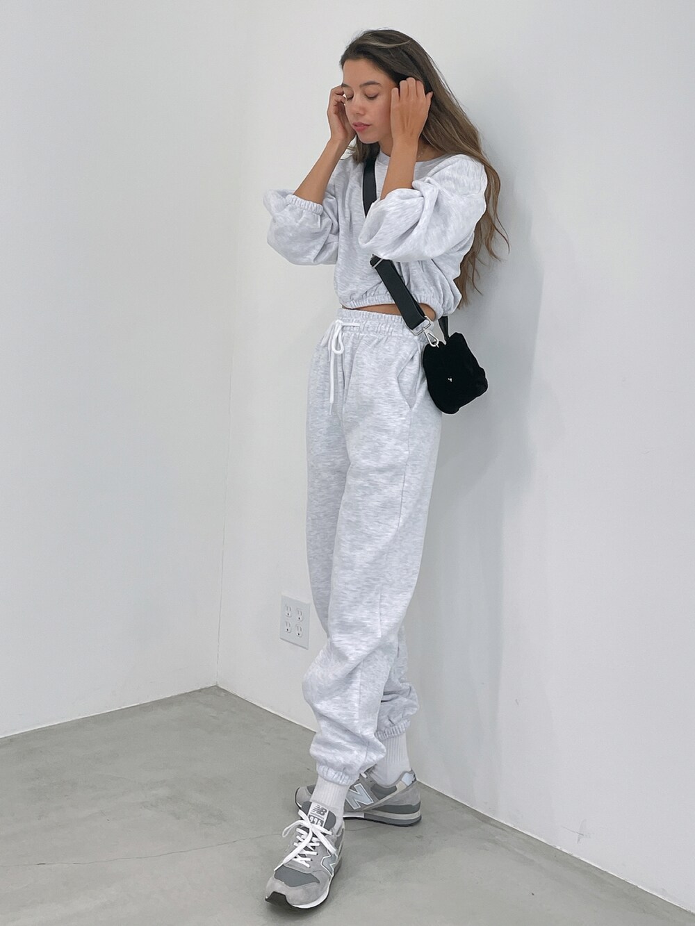 ホワイト系のスウェットパンツ、ブラック系のショルダーバッグ、グレー系のスニーカーを着用したレディースの冬コーディネートの2枚目の写真