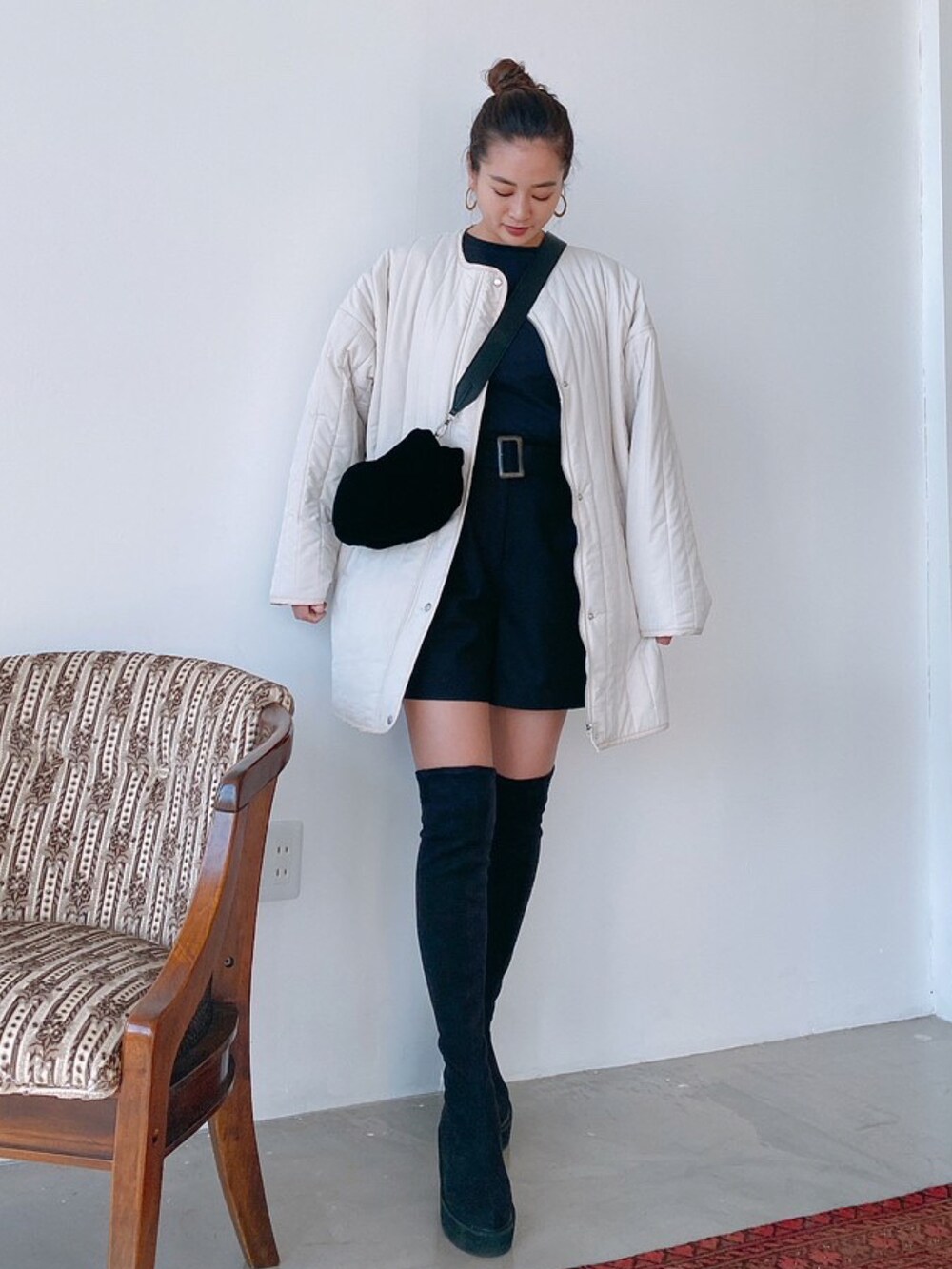 ホワイト系のその他アウター、ブラック系のニット/セーター、ブラック系のその他パンツを着用したレディースの秋コーディネートの2枚目の写真