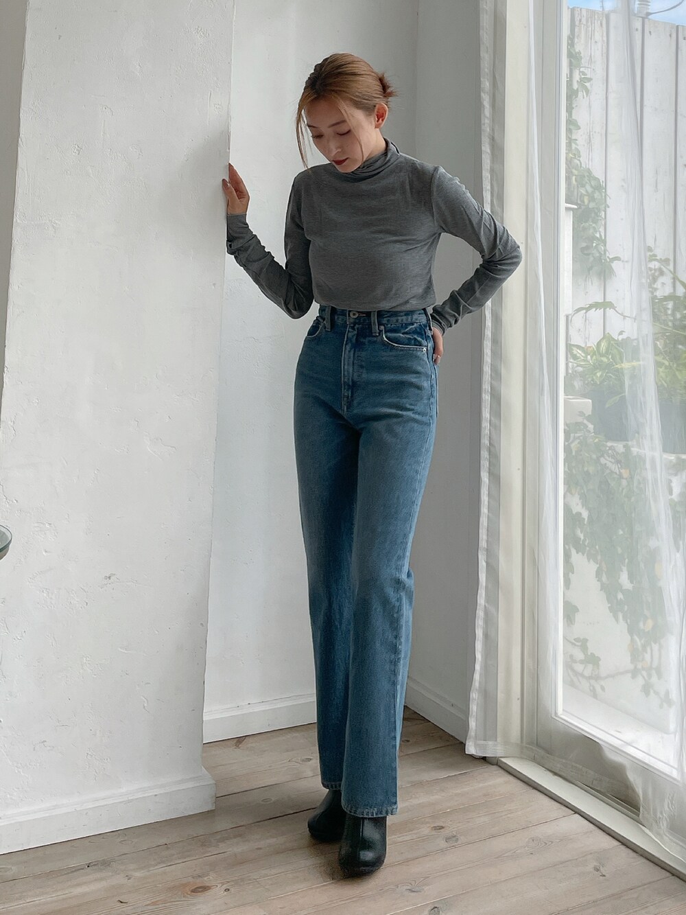 グレー系のTシャツ/カットソー、ブルー系のデニムパンツ、ブラック系のブーツを着用したレディースの秋コーディネートの2枚目の写真