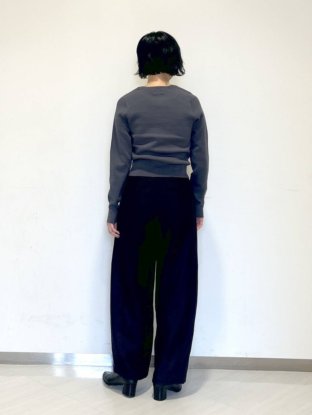 ブラック系のその他パンツ、ブラック系のブーツ、グレー系のニット/セーターを着用したレディースの秋コーディネートの2枚目の写真
