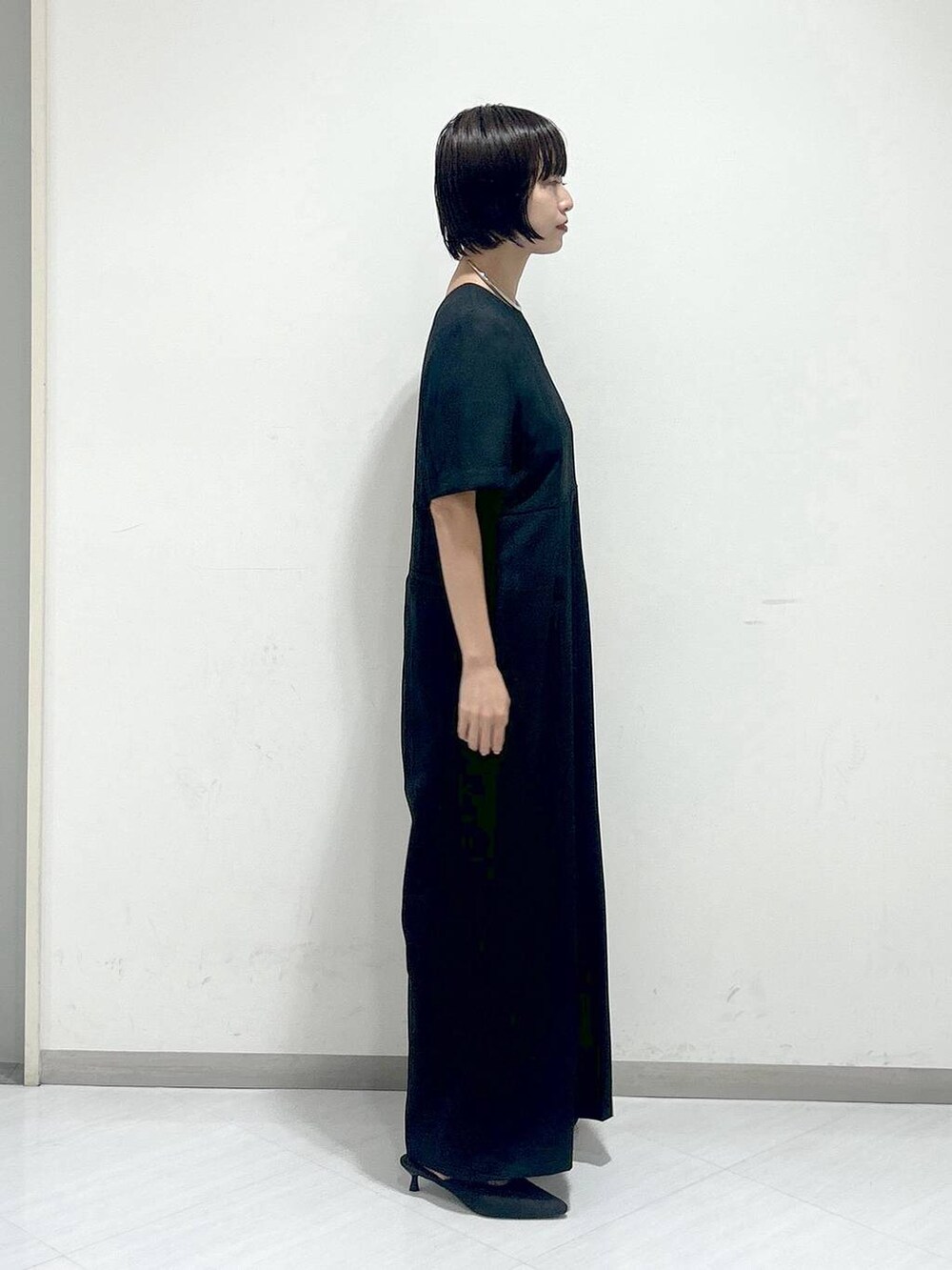 ブラウン系のパンプス、ブラック系のつなぎ/オールインワン、シルバー系のネックレスを着用したレディースの秋コーディネートの2枚目の写真