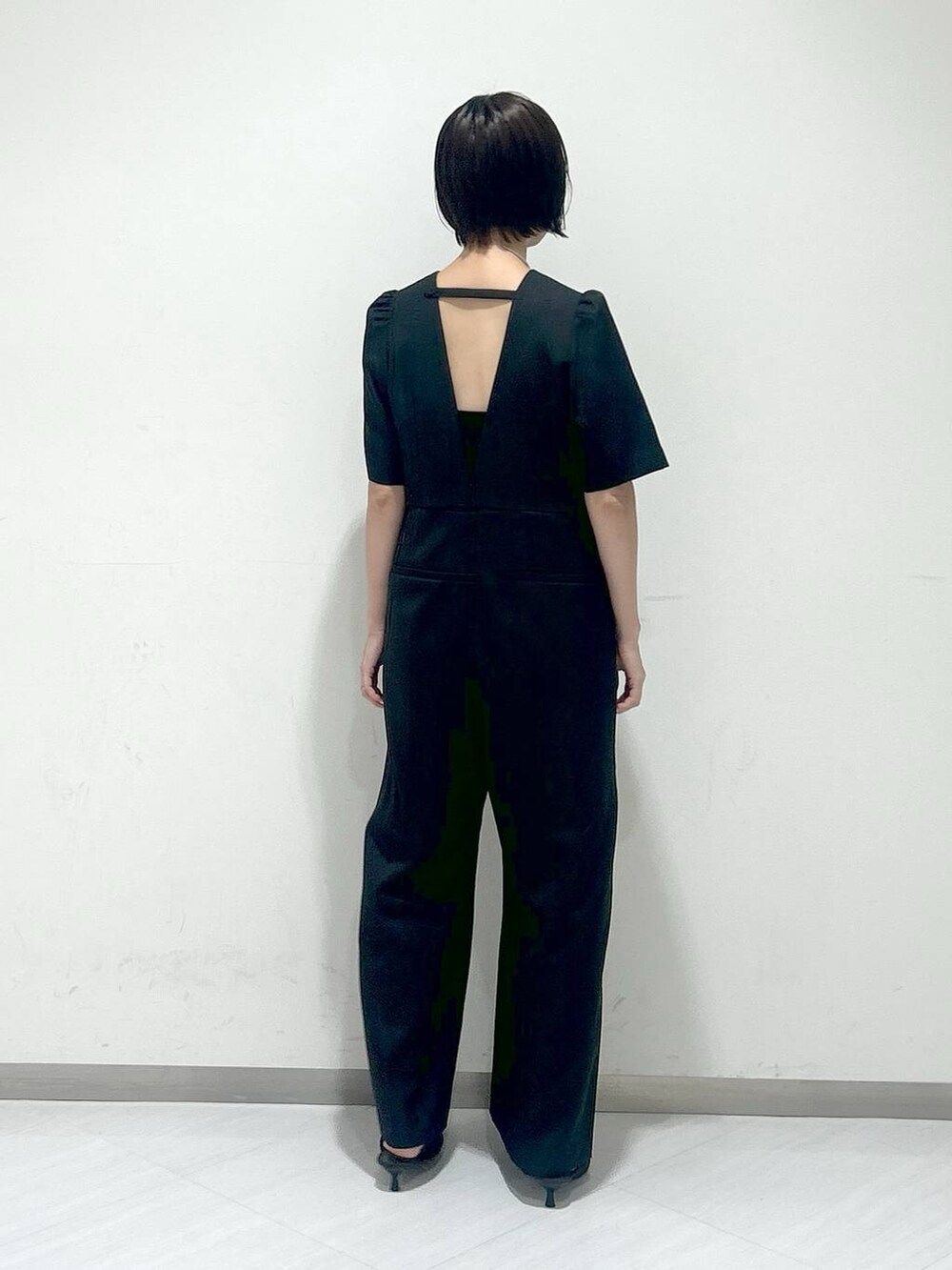 ブラウン系のパンプス、ブラック系のつなぎ/オールインワン、シルバー系のネックレスを着用したレディースの秋コーディネートの3枚目の写真