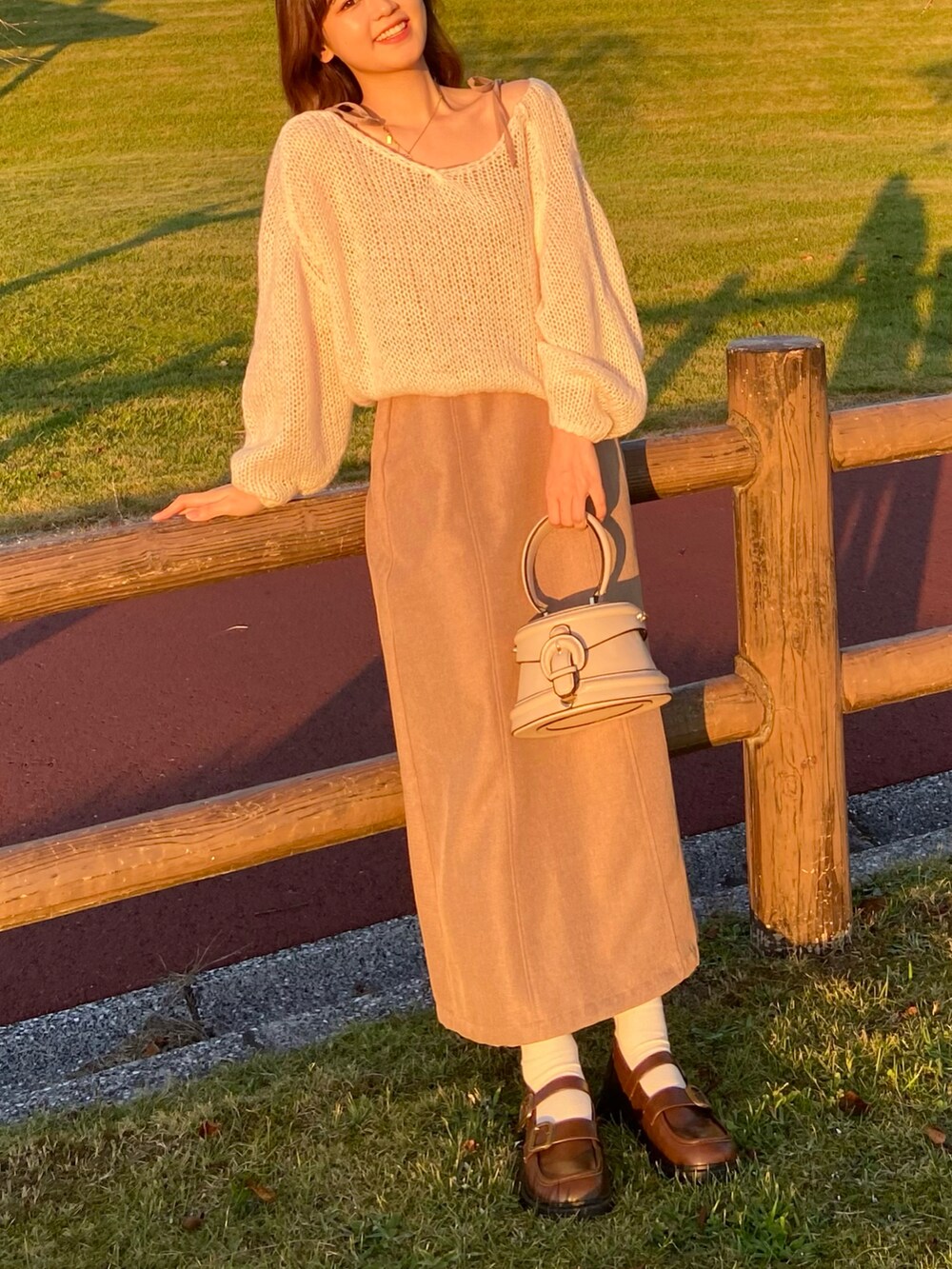 ブラウン系のワンピース、ベージュ系のニット/セーター、ブラウン系のローファーを着用したレディースの秋コーディネートの2枚目の写真