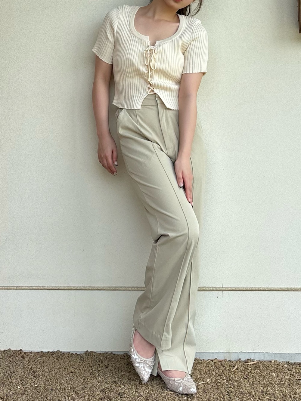 ホワイト系のトップス、グリーン系のスラックス、ホワイト系のパンプスを着用したレディースの夏コーディネートの3枚目の写真