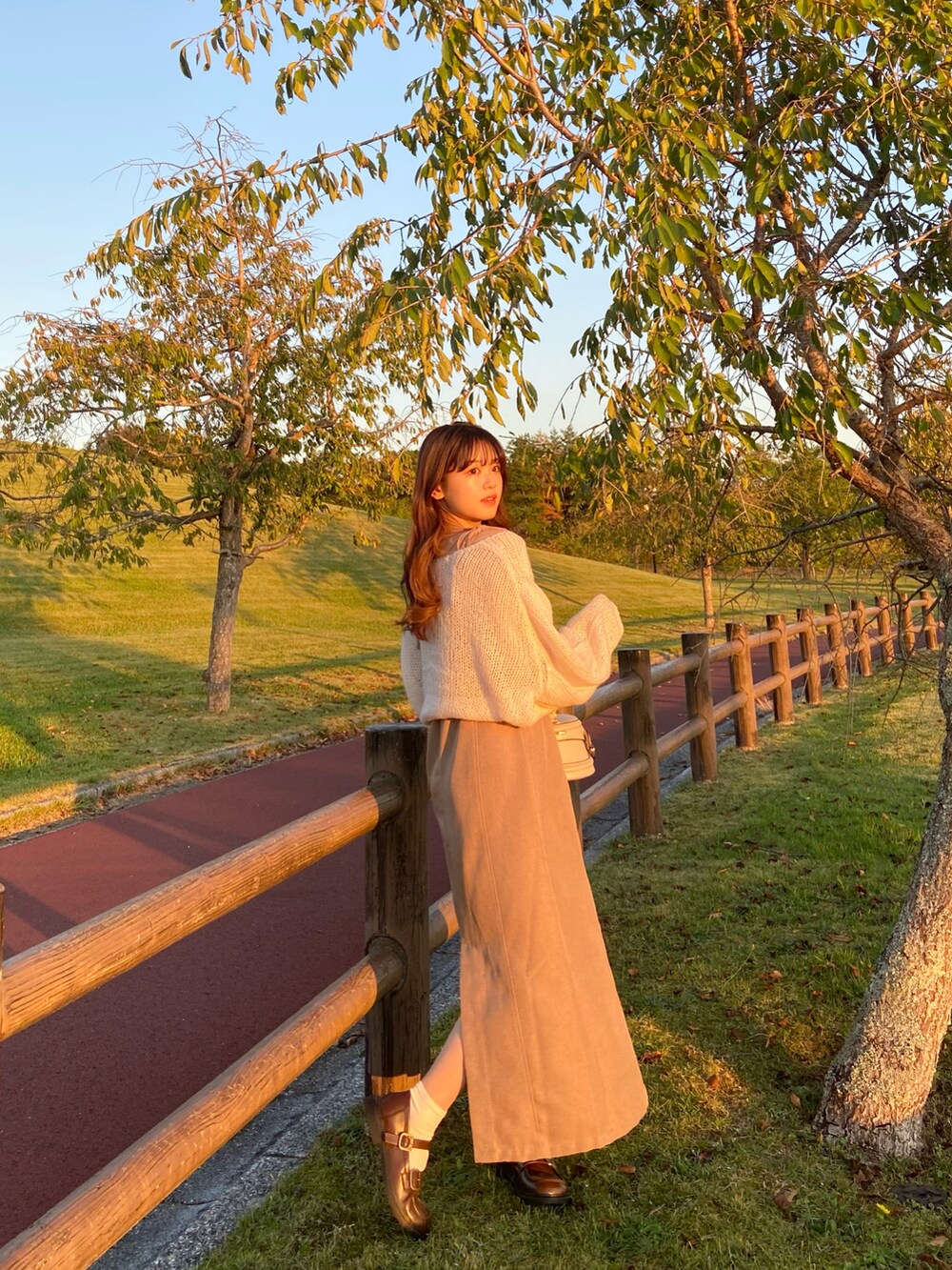 ブラウン系のワンピース、ベージュ系のニット/セーター、ブラウン系のローファーを着用したレディースの秋コーディネートの3枚目の写真