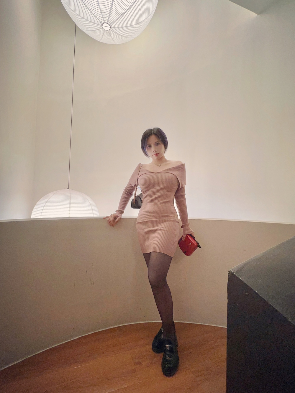 ピンク系のワンピース、ブラウン系のショルダーバッグ、ブラック系のローファーを着用したレディースの冬コーディネートの3枚目の写真