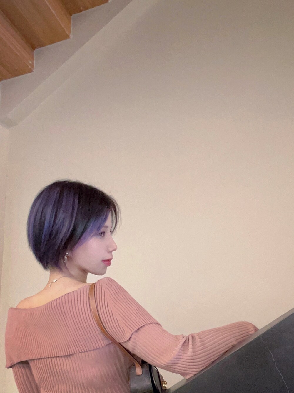 ピンク系のワンピース、ブラウン系のショルダーバッグ、ブラック系のローファーを着用したレディースの冬コーディネートの2枚目の写真