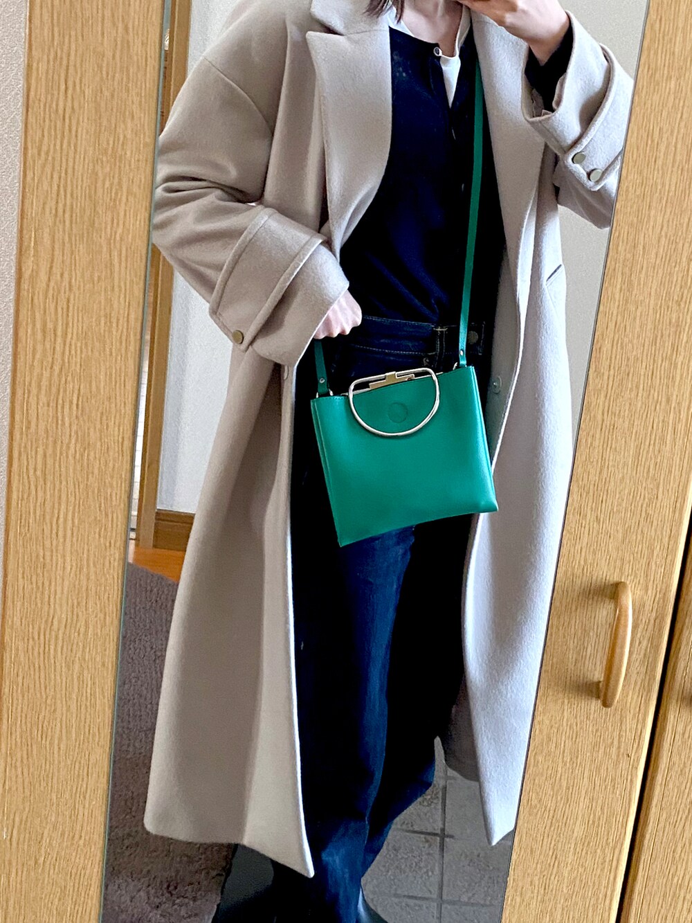 ブラック系のカーディガン/ボレロ、ブルー系のデニムパンツ、グリーン系のショルダーバッグを着用したレディースの春コーディネートの2枚目の写真