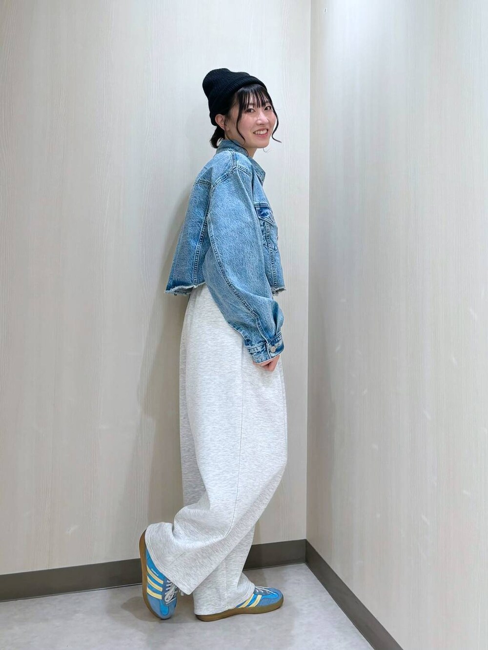 ブルー系のデニムジャケット、ブラック系のショルダーバッグ、グレー系のスウェットパンツを着用したレディースの冬コーディネートの2枚目の写真