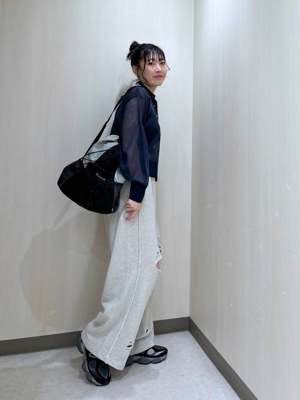 グレー系のスウェットパンツ、ブルー系のニット/セーター、ブラック系のバックパック/リュックを着用したレディースの冬コーディネートの2枚目の写真