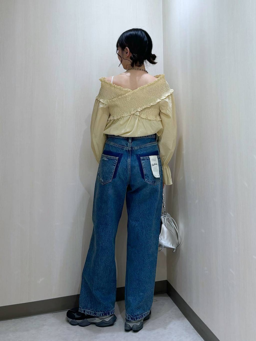 ブルー系のデニムパンツ、シルバー系のショルダーバッグ、イエロー系のシャツ/ブラウスを着用したレディースの冬コーディネートの3枚目の写真