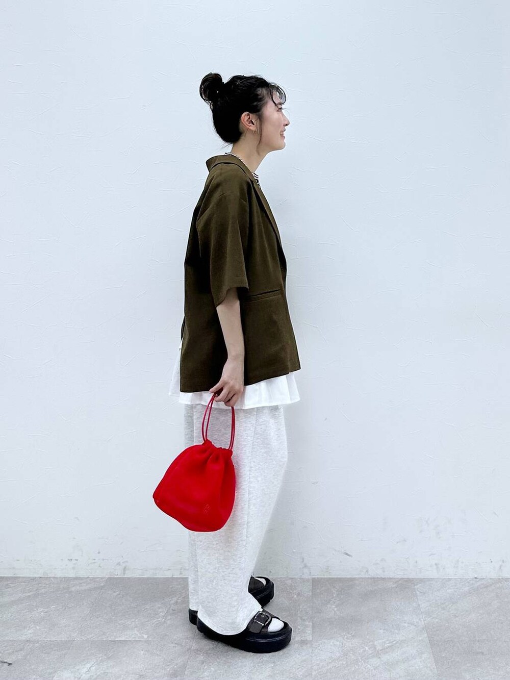 ブルー系のTシャツ/カットソー、ブラウン系のテーラードジャケット、レッド系のショルダーバッグを着用したレディースの夏コーディネートの2枚目の写真