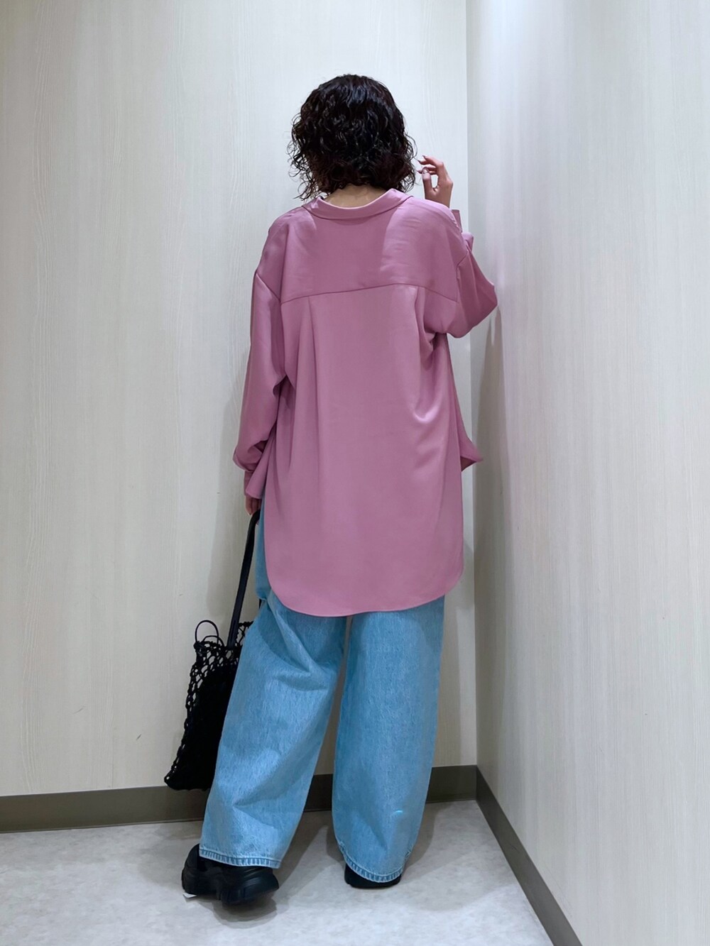 ピンク系のトップス、ブルー系のデニムパンツ、ブラック系のタンクトップを着用したレディースの春コーディネートの4枚目の写真