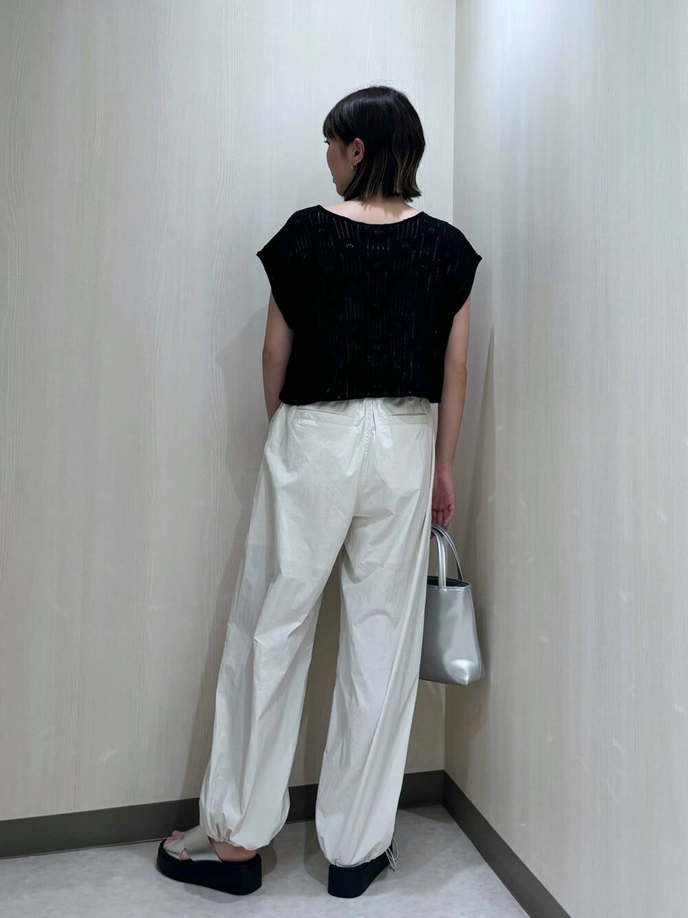 ホワイト系のその他パンツ、シルバー系のショルダーバッグ、ブラック系のニット/セーターを着用したレディースの夏コーディネートの3枚目の写真