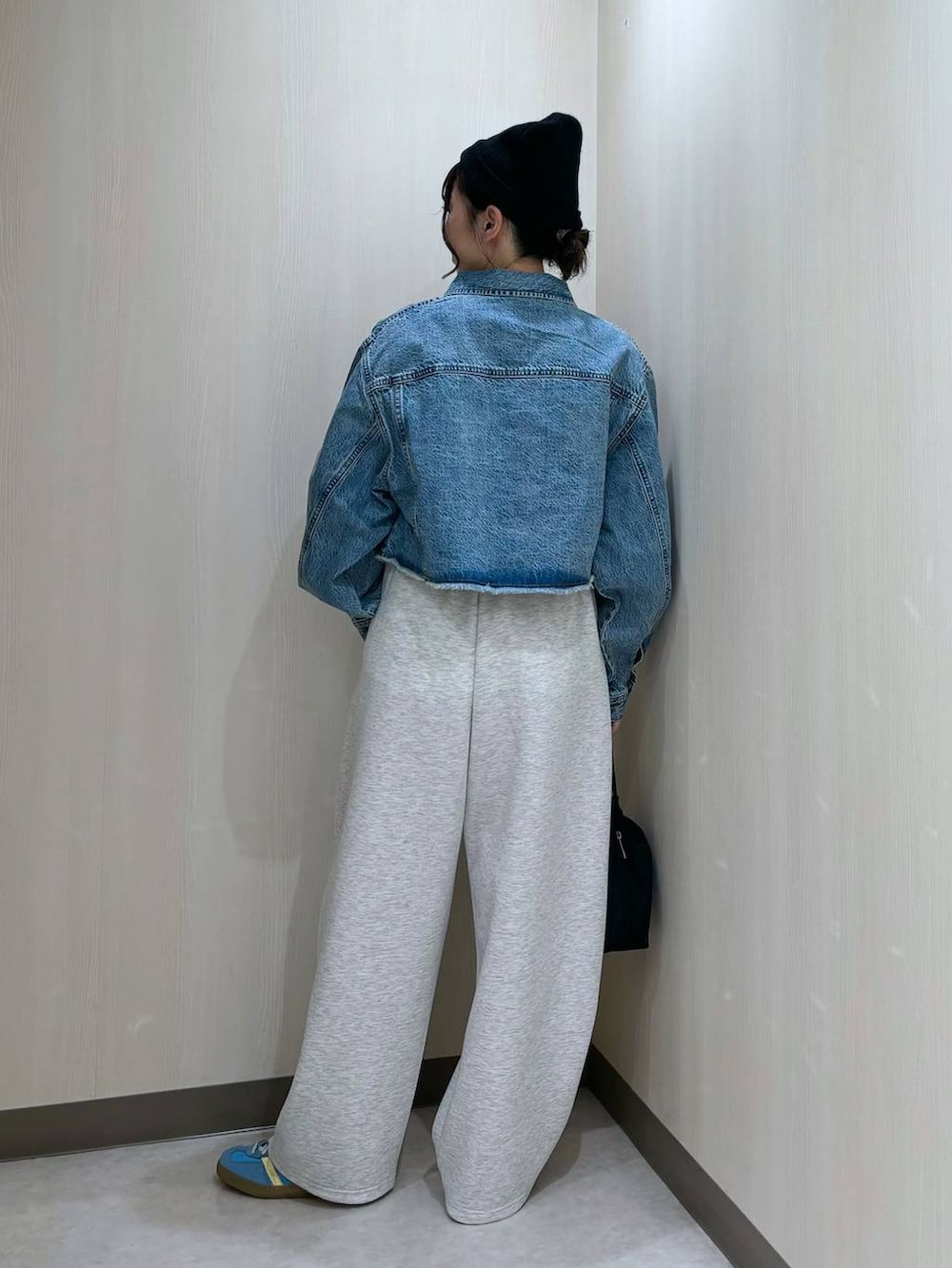 ブルー系のデニムジャケット、ブラック系のショルダーバッグ、グレー系のスウェットパンツを着用したレディースの冬コーディネートの3枚目の写真