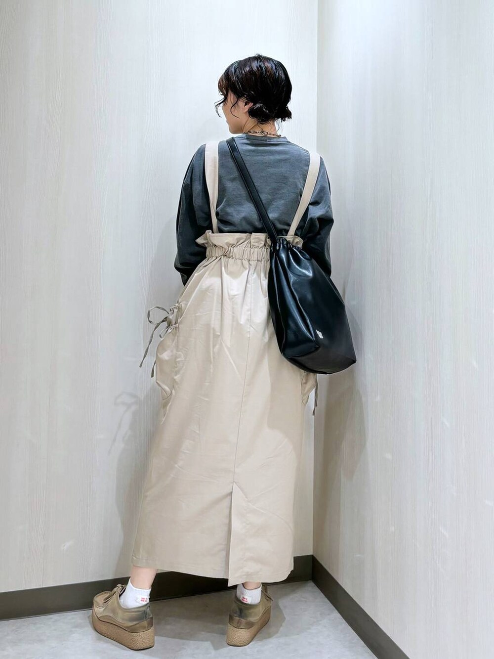 ブラック系のショルダーバッグ、グレー系のTシャツ/カットソー、ベージュ系のスカートを着用したレディースの秋コーディネートの2枚目の写真