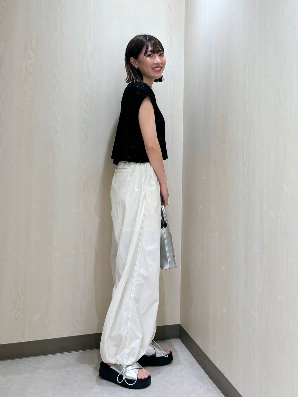ホワイト系のその他パンツ、シルバー系のショルダーバッグ、ブラック系のニット/セーターを着用したレディースの夏コーディネートの2枚目の写真