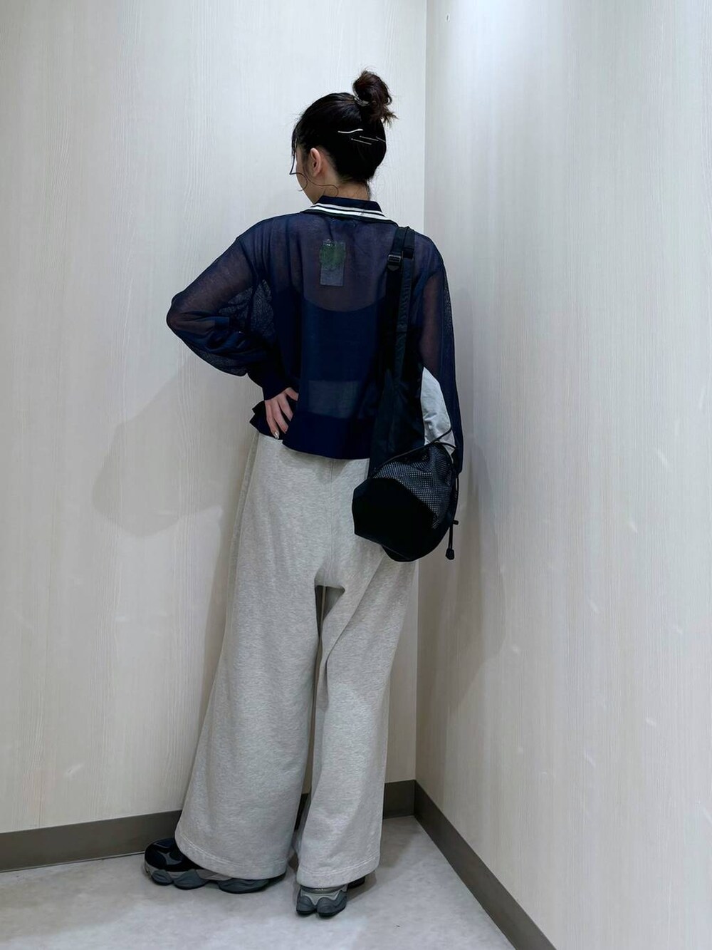 グレー系のスウェットパンツ、ブルー系のニット/セーター、ブラック系のバックパック/リュックを着用したレディースの冬コーディネートの3枚目の写真