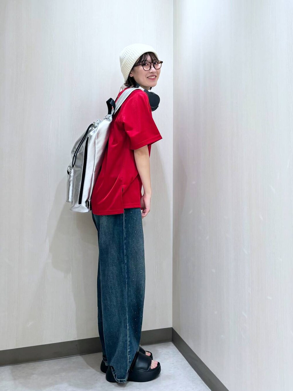 ブルー系のデニムパンツ、シルバー系のショルダーバッグ、レッド系のTシャツ/カットソーを着用したレディースの夏コーディネートの2枚目の写真