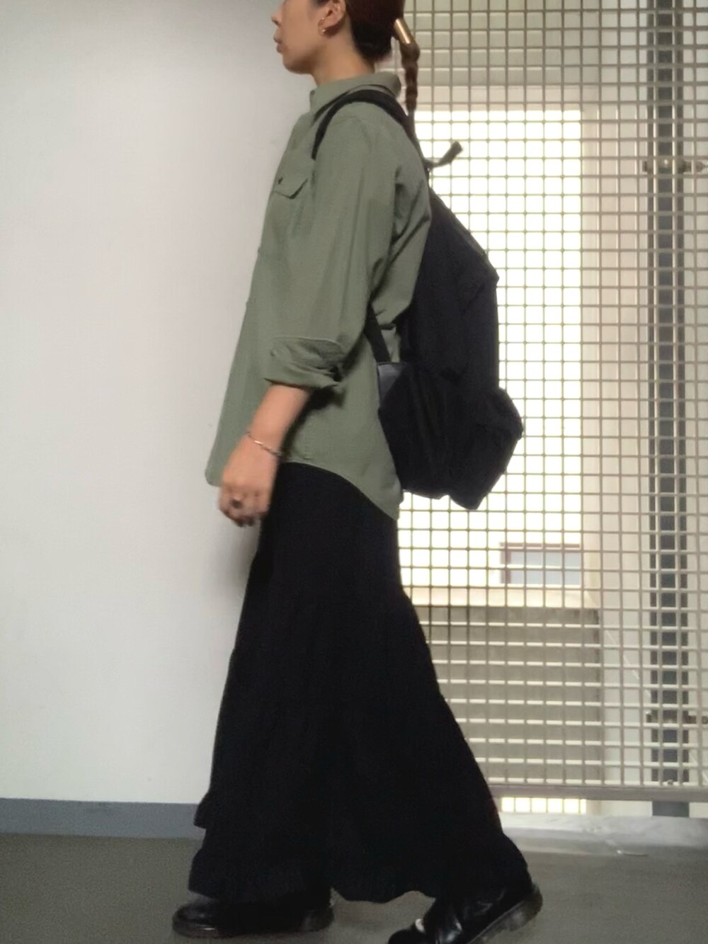 グリーン系のシャツ/ブラウス、ブラック系のバックパック/リュック、ブラック系のブーツを着用したレディースの秋コーディネートの2枚目の写真