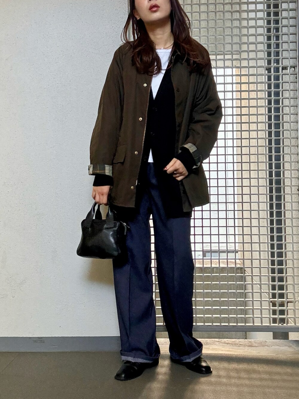 ブラック系のカーディガン/ボレロ、ブルー系のスラックス、ブラック系のサンダルを着用したレディースの秋コーディネートの2枚目の写真