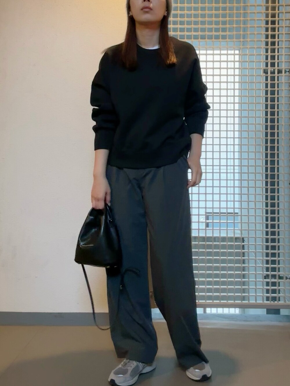 ブラック系のジャケット/アウター、グレー系のスラックス、グレー系のスニーカーを着用したレディースの春コーディネートの2枚目の写真