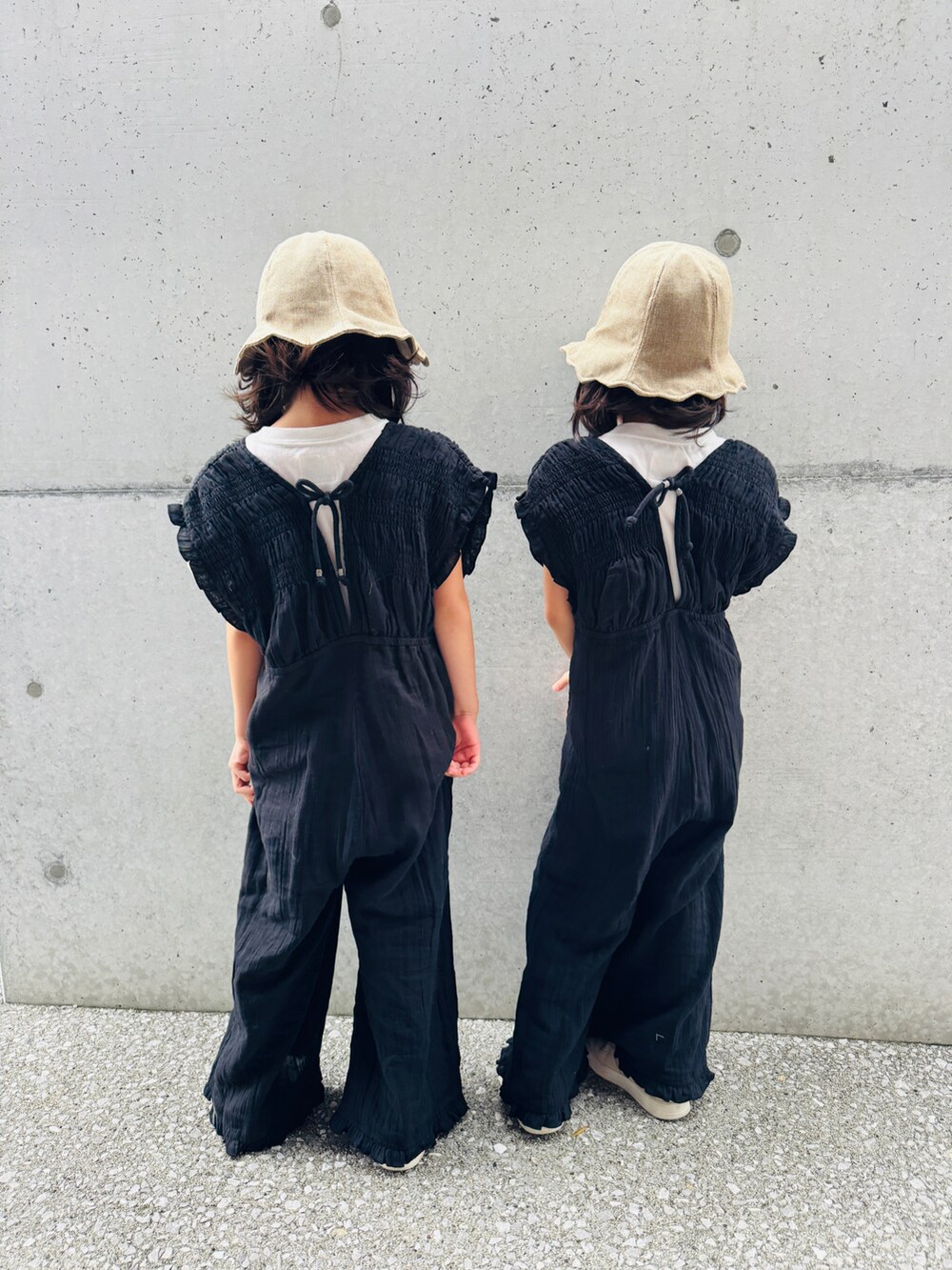 ホワイト系のTシャツ/カットソー、ホワイト系のスニーカー、ブラック系のサロペット/オーバーオールを着用したキッズの秋コーディネートの2枚目の写真