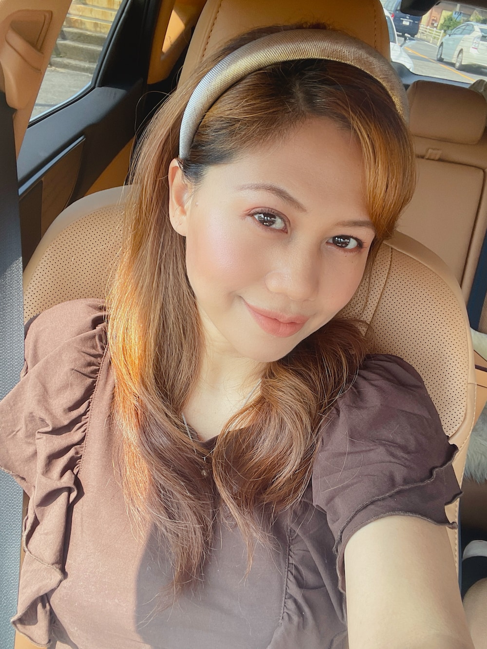 ピンク系のハンドバッグ、ベージュ系のスカート、ブラウン系のトップスを着用したレディースの夏コーディネートの3枚目の写真