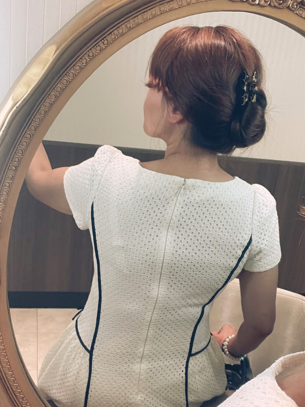 ブラック系のハンドバッグ、ホワイト系のワンピース、ブラウン系のバレッタ/ヘアクリップを着用したレディースの夏コーディネートの3枚目の写真