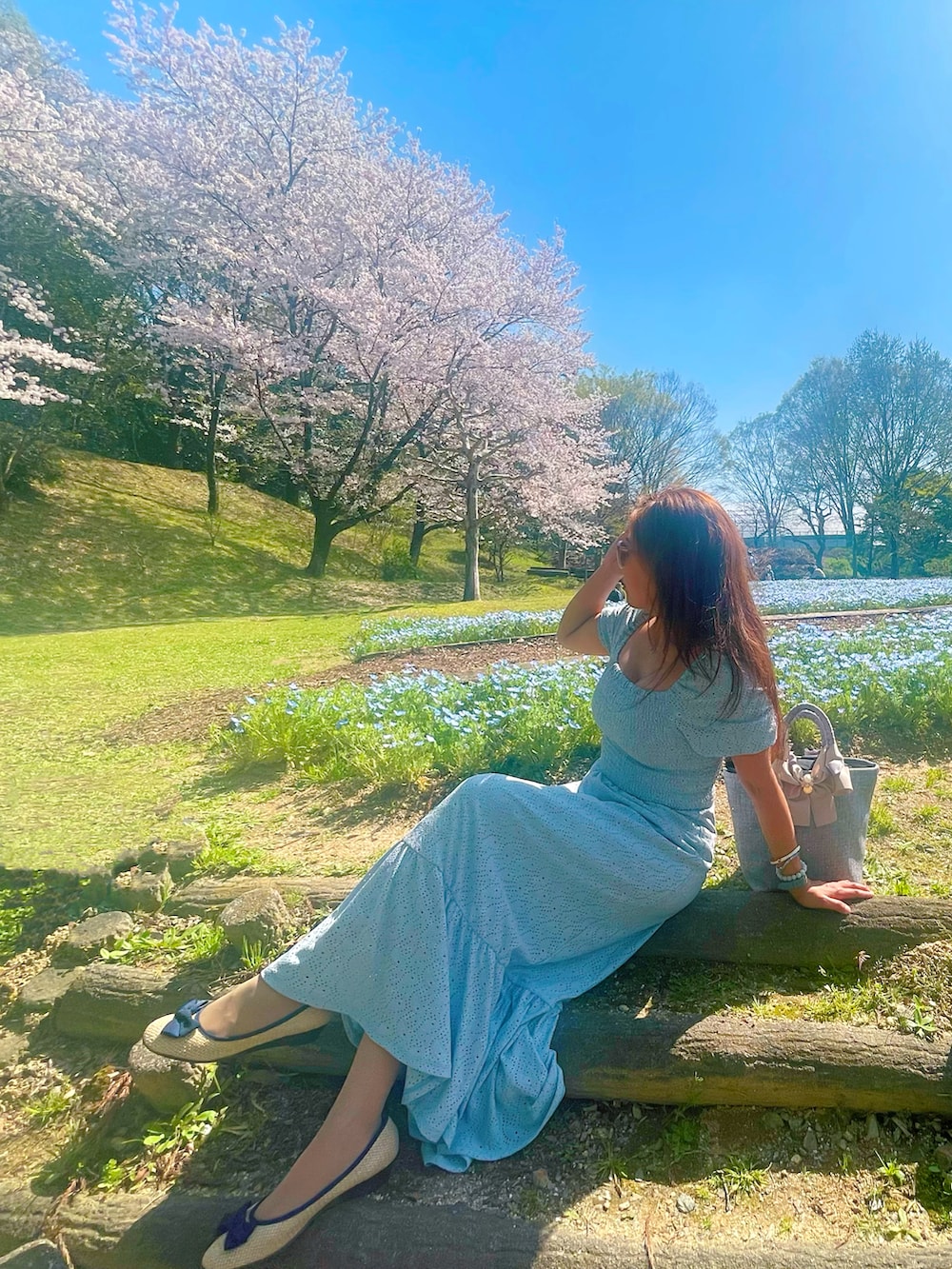 ブルー系のワンピースを着用したレディースの春コーディネートの3枚目の写真