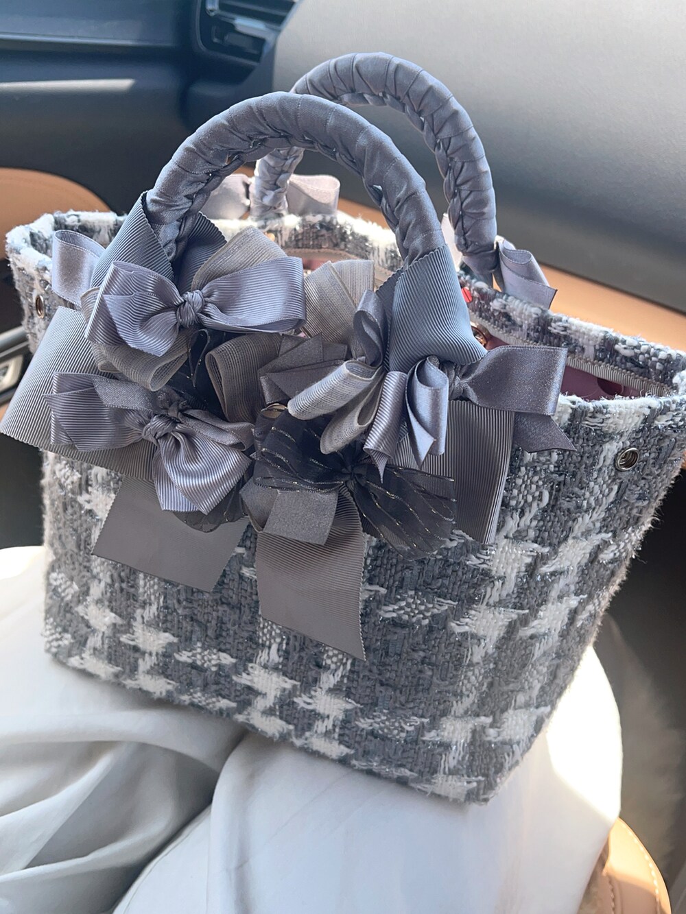 シルバー系のハンドバッグ、ベージュ系のワンピース/ドレス、グレー系のパンプスを着用したレディースの夏コーディネートの3枚目の写真