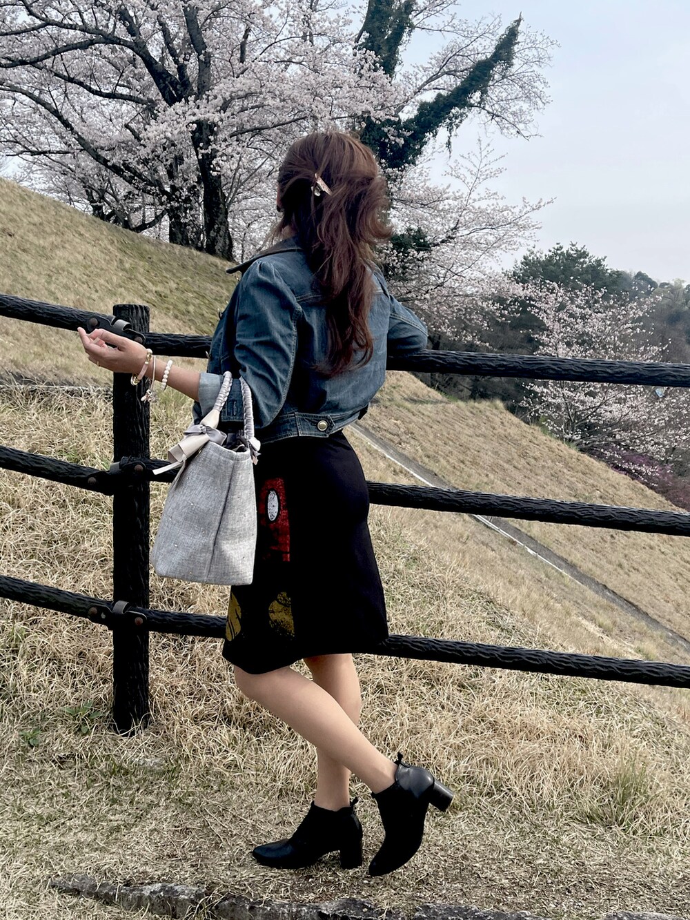 ブラック系のワンピース、ブラック系のブーツを着用したレディースの春コーディネートの3枚目の写真