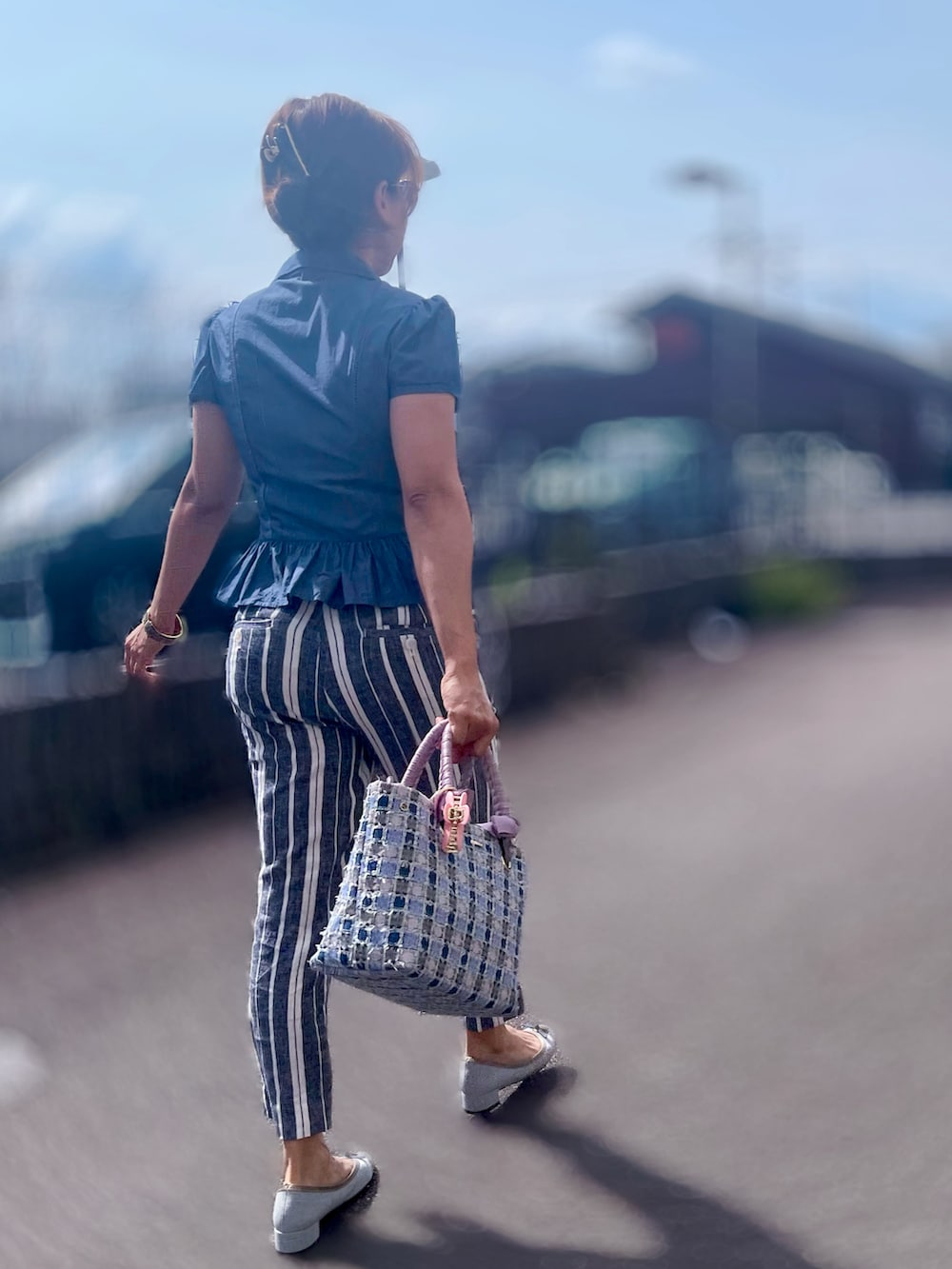 ブルー系のハンドバッグ、ブルー系のシューズ、ブルー系のトップスを着用したレディースの春コーディネートの3枚目の写真