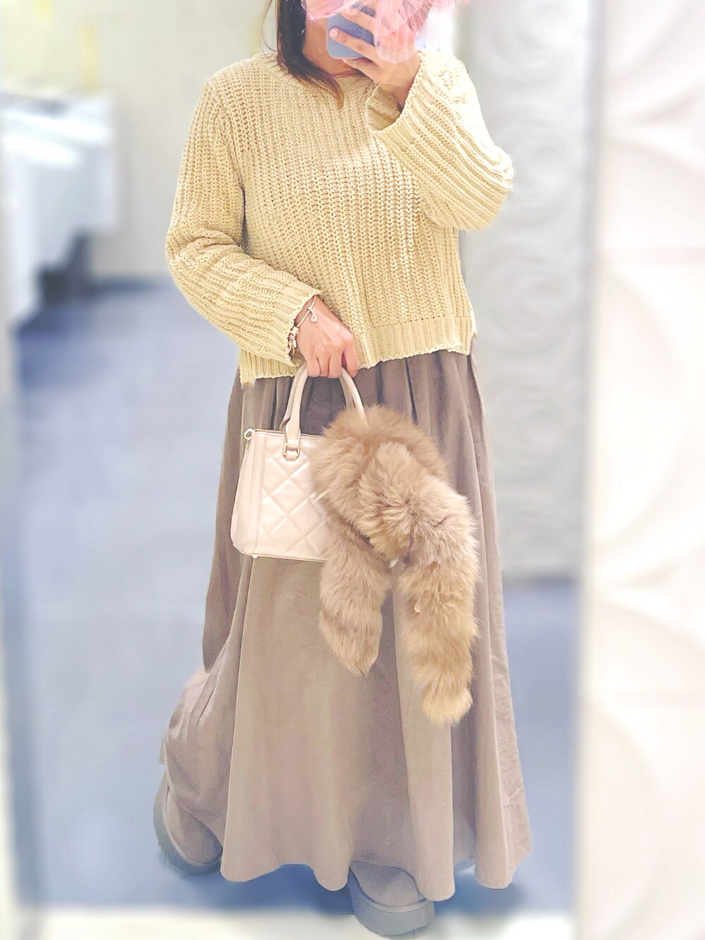 ベージュ系のブーツ、シルバー系のブレスレット、ピンク系のバレッタ/ヘアクリップを着用したレディースの冬コーディネートの2枚目の写真