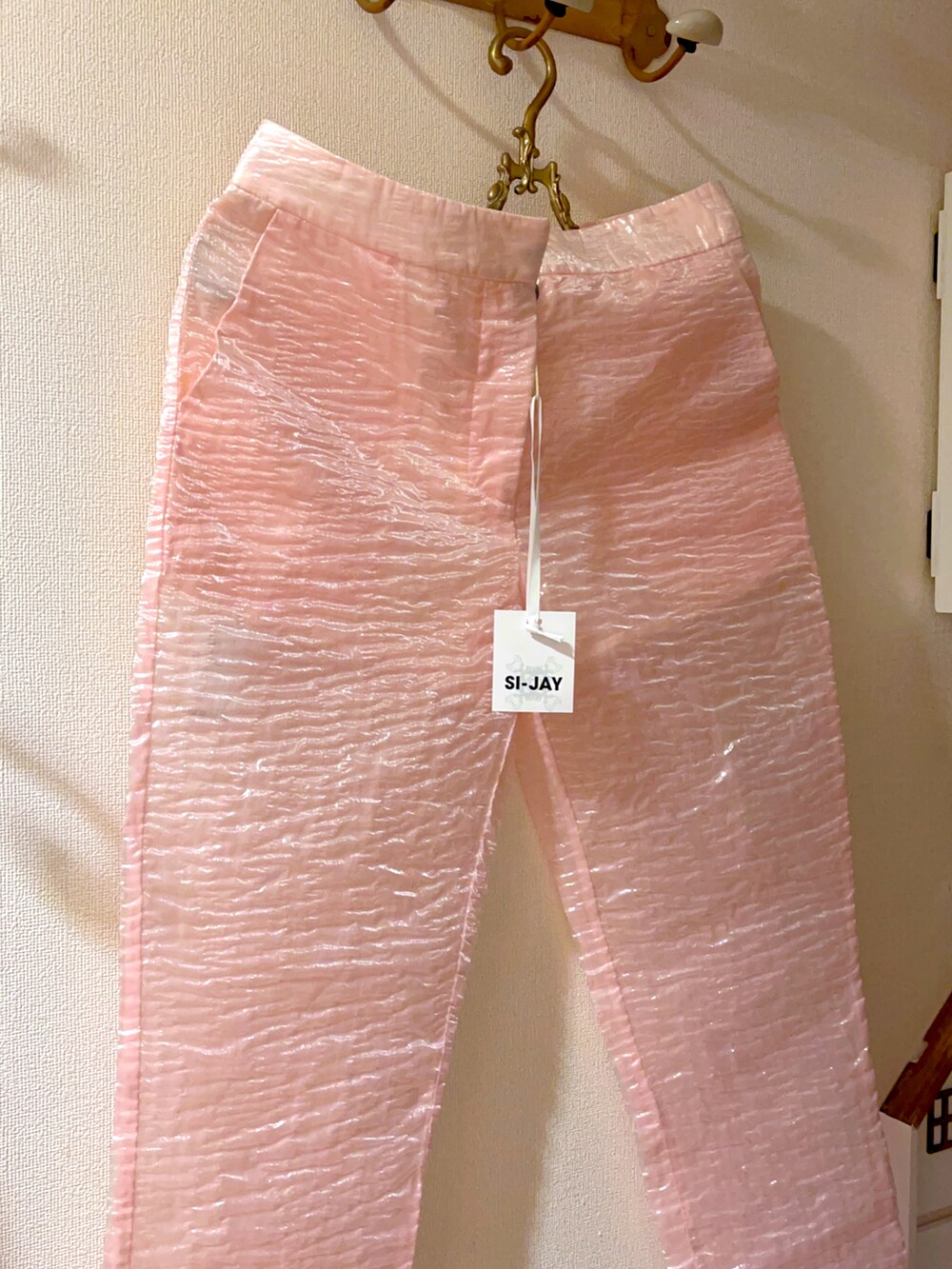 ブラック系のショルダーバッグ、ホワイト系のシューズ、ピンク系のパンツを着用したレディースの夏コーディネートの3枚目の写真