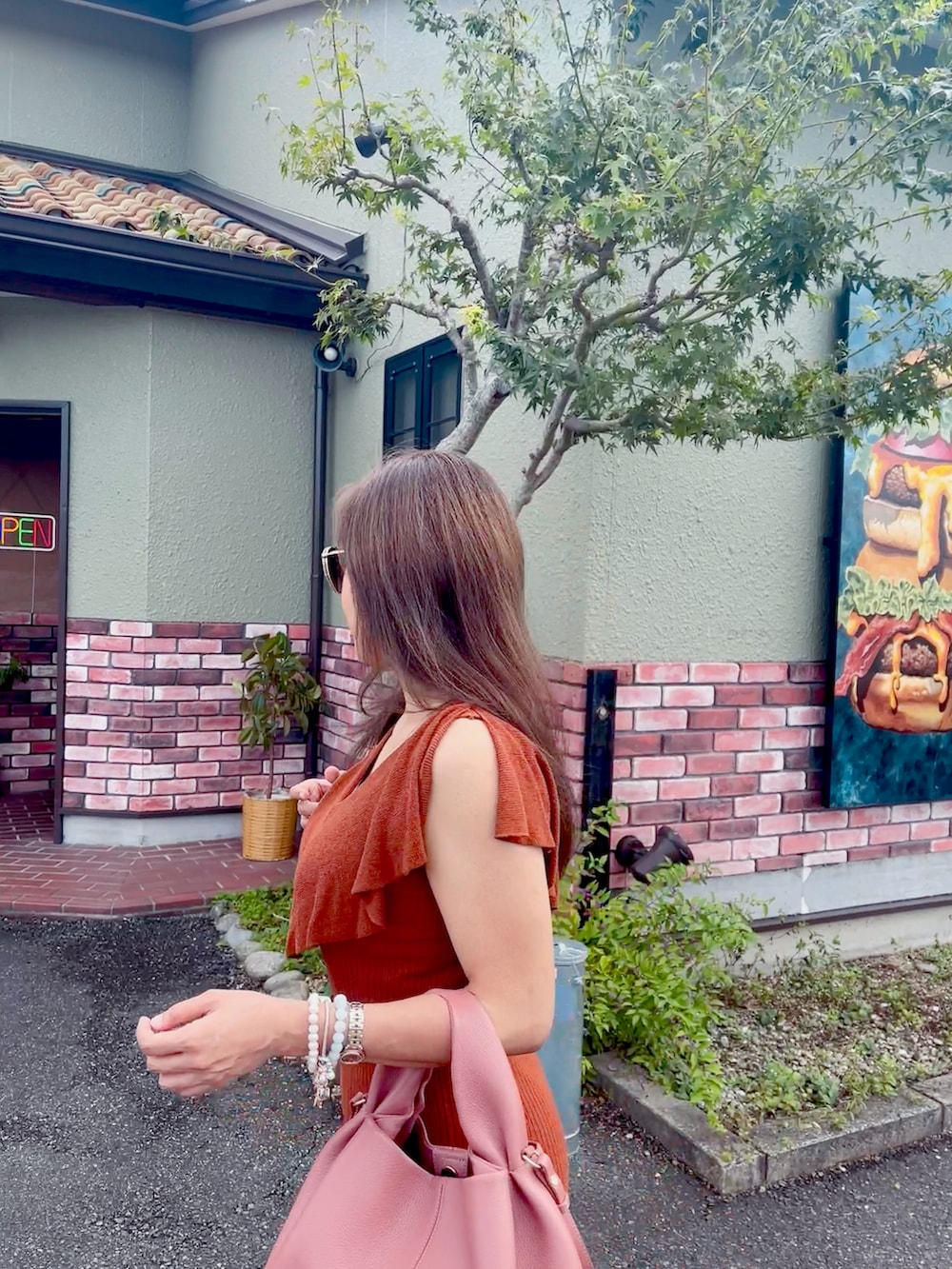 ブラウン系のワンピース、その他のハンドバッグ、その他のパンプスを着用したレディースの秋コーディネートの2枚目の写真