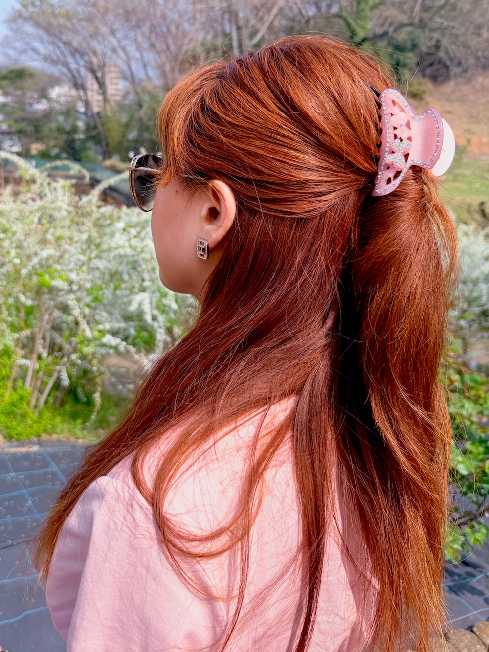 ピンク系のワンピース、レッド系のブーツ、ピンク系のハンドバッグを着用したレディースの春コーディネートの2枚目の写真