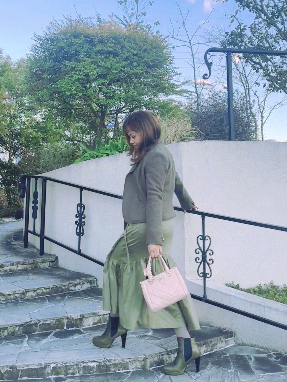 グリーン系のワンピース、グリーン系のブーツ、その他のジャケット/アウターを着用したレディースの冬コーディネートの2枚目の写真