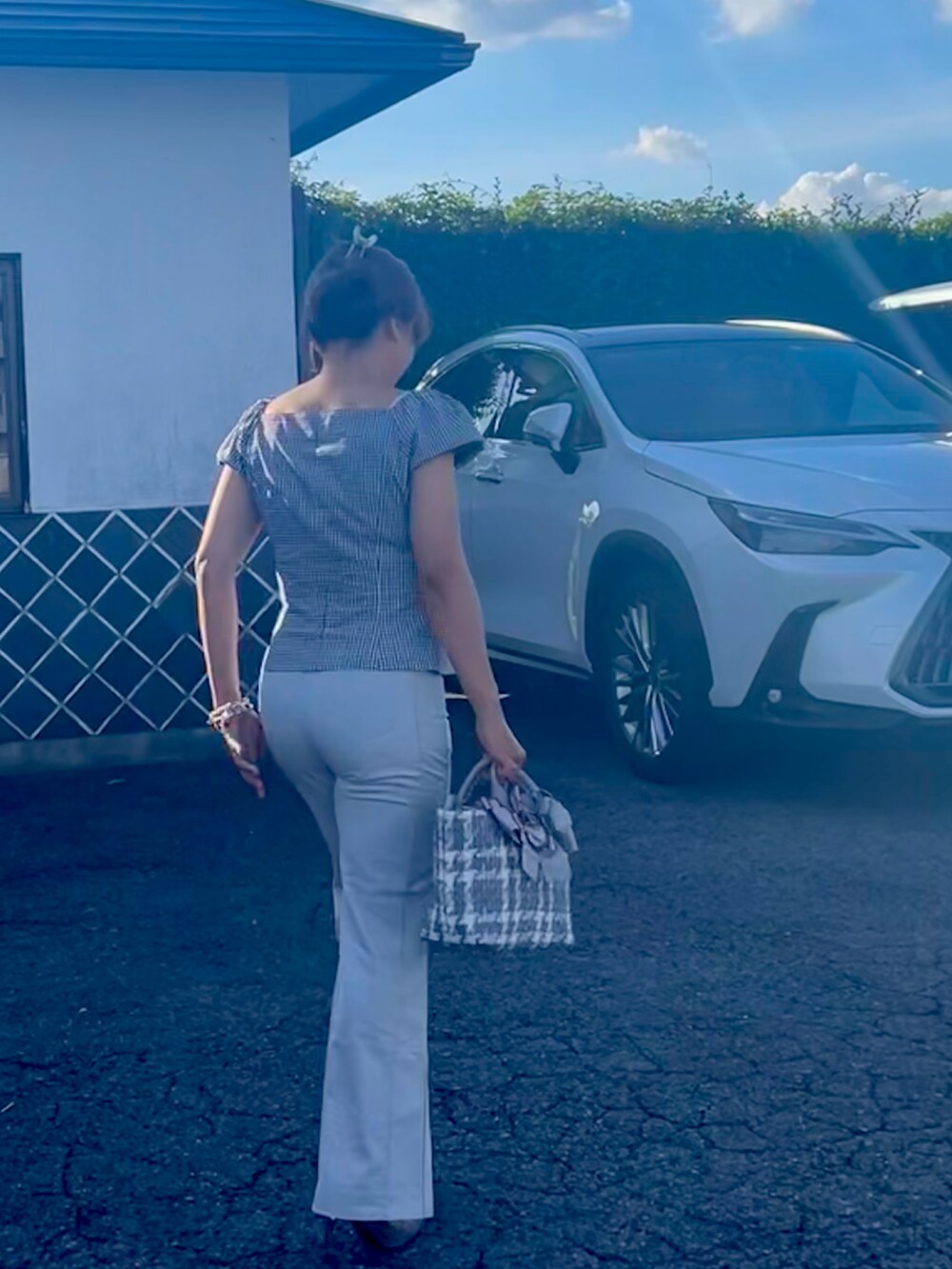 シルバー系のハンドバッグ、グレー系のパンプス、ブラック系のバレッタ/ヘアクリップを着用したレディースの夏コーディネートの2枚目の写真