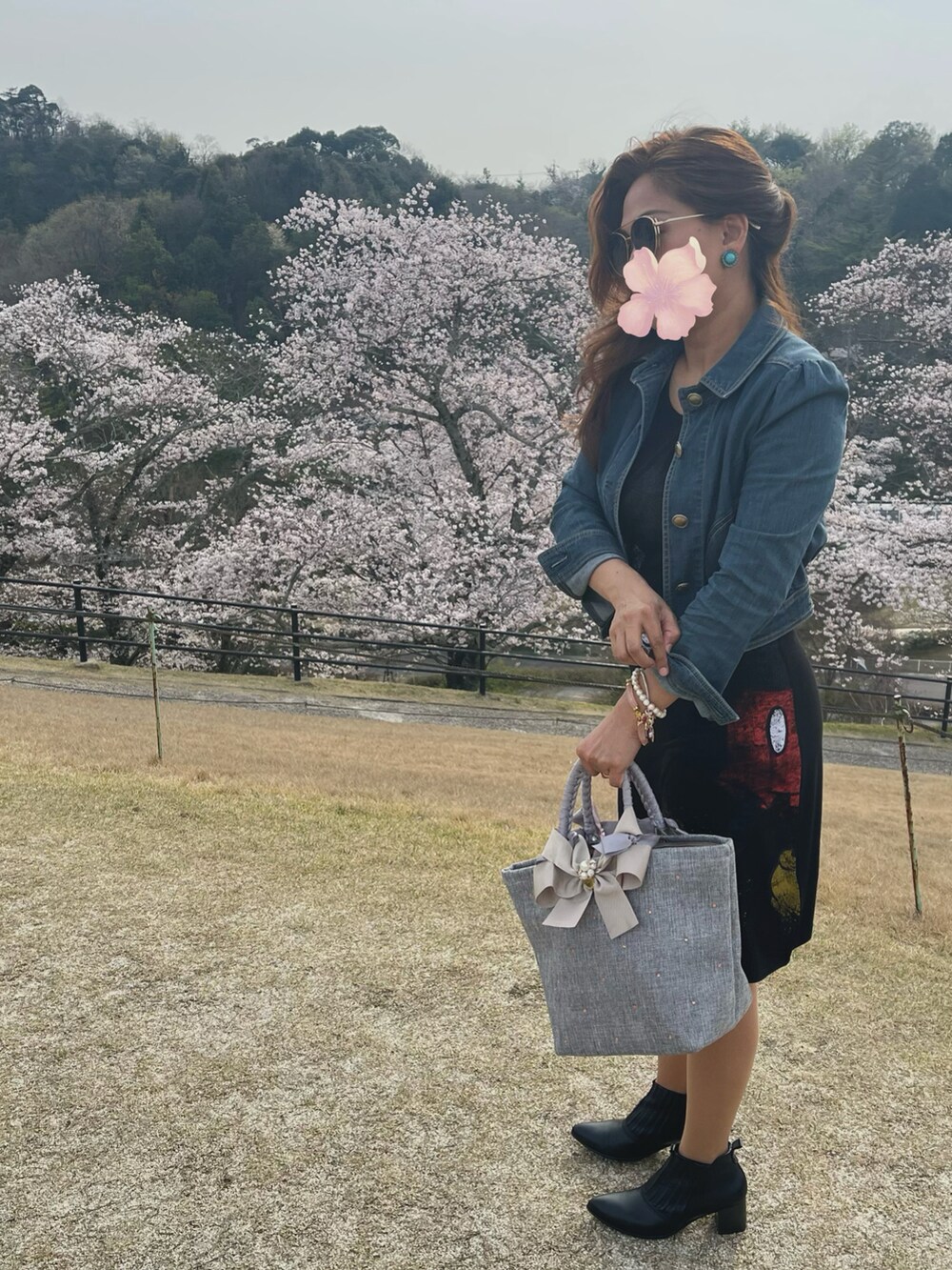 ブラック系のブーツ、ブラック系のワンピース、ブルー系のデニムジャケットを着用したレディースの春コーディネートの2枚目の写真