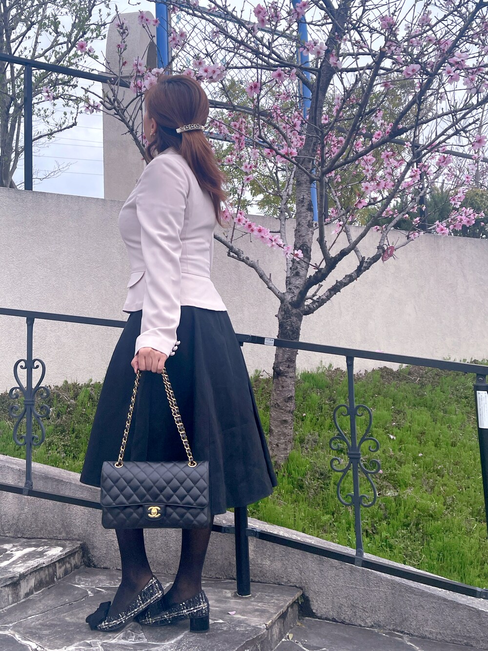 ブラック系のシューズ、ブラック系のショルダーバッグ、ブラック系のスカートを着用したレディースの春コーディネートの2枚目の写真