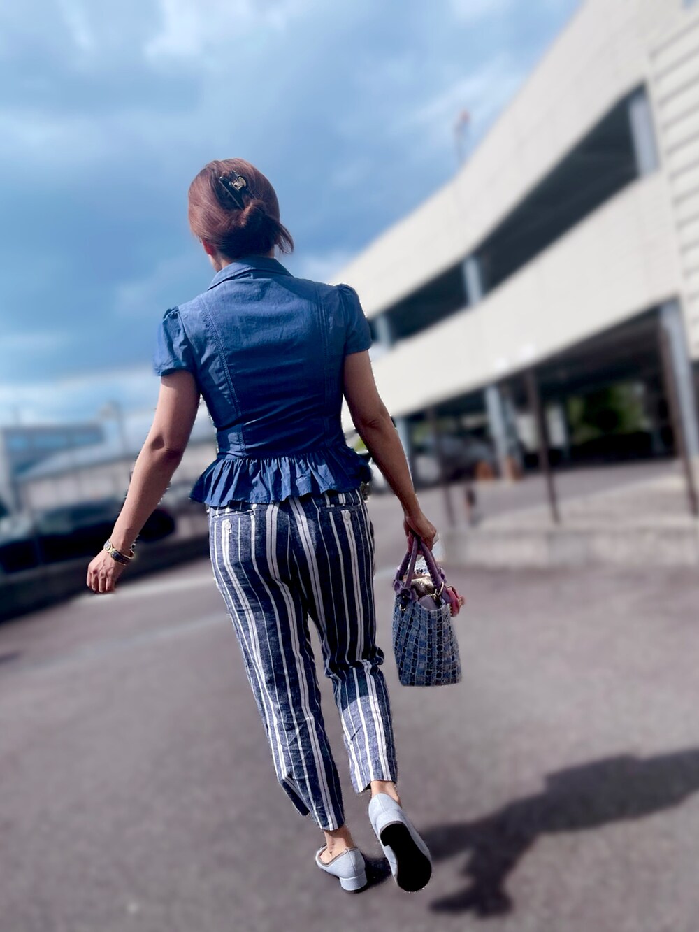 ブルー系のハンドバッグ、ブルー系のシューズ、ブルー系のトップスを着用したレディースの春コーディネートの2枚目の写真