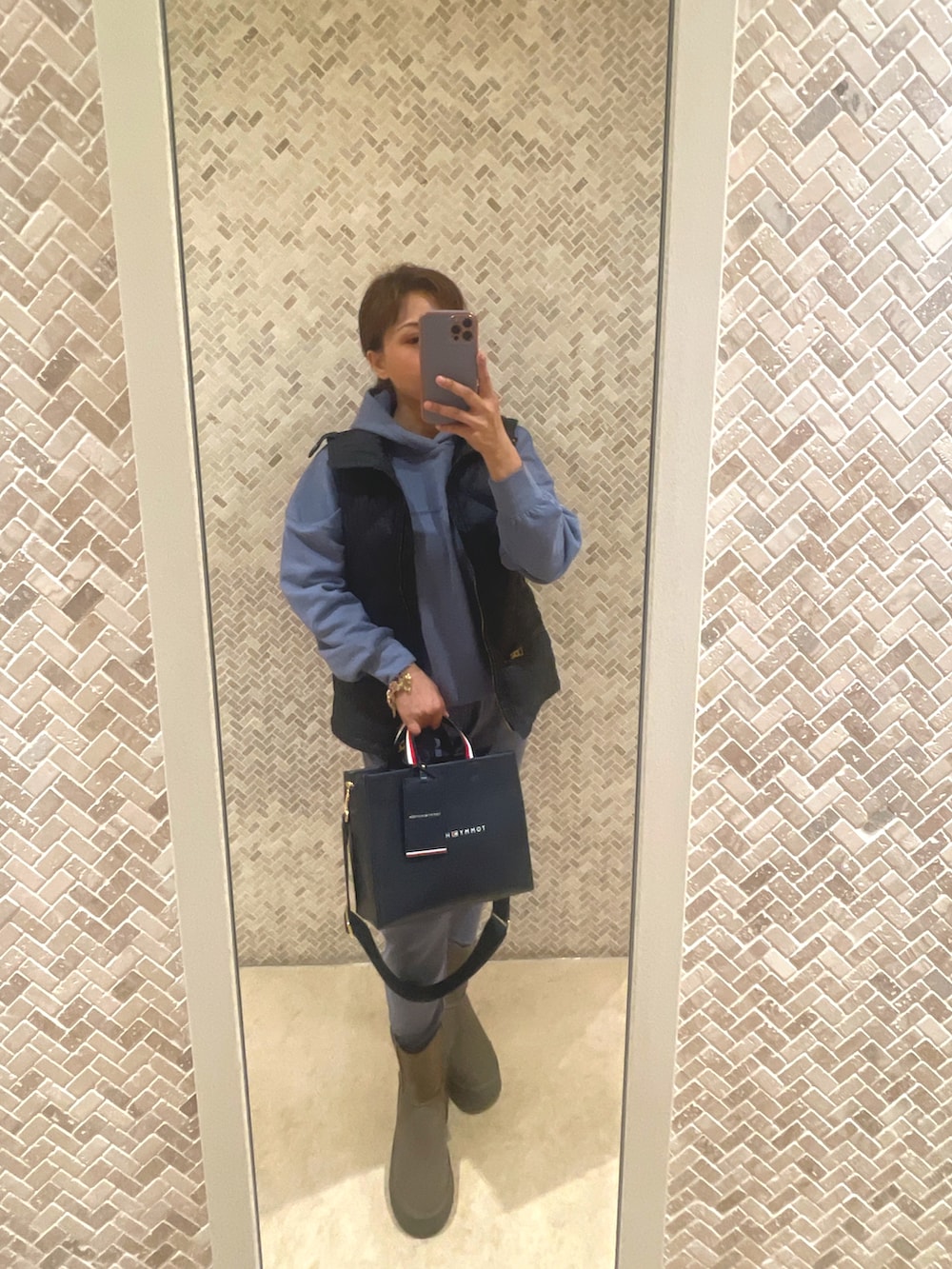 ベージュ系のブーツ、ブルー系のトートバッグ、ブルー系のパーカーを着用したレディースの冬コーディネートの2枚目の写真