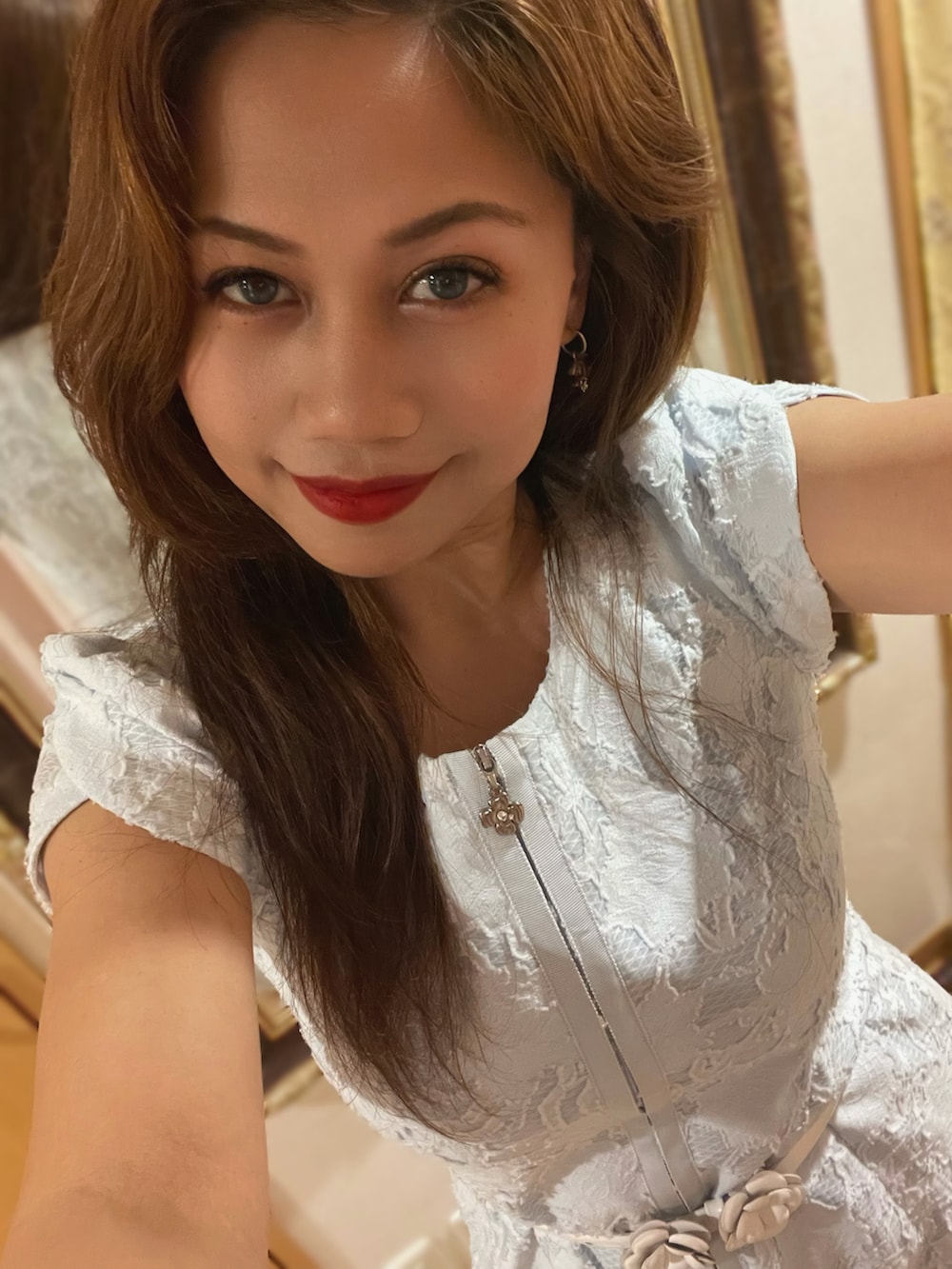 グレー系のパンプス、ブルー系のワンピース/ドレス、ブラック系のハンドバッグを着用したレディースの春コーディネートの2枚目の写真