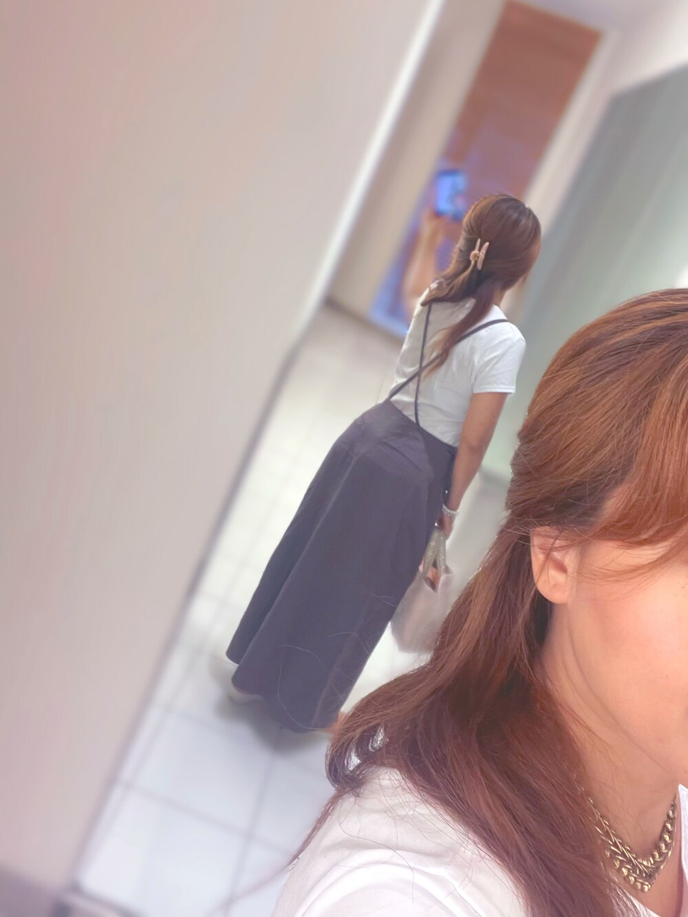 ホワイト系のTシャツ/カットソー、ピンク系のハンドバッグ、グレー系のスカートを着用したレディースの夏コーディネートの2枚目の写真